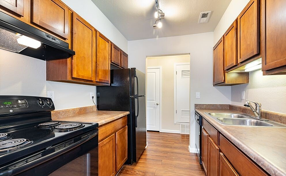 Charming kitchen with elegant wood cabinetry, modern appliances, and warm hardwood flooring, creating a cozy cooking space.