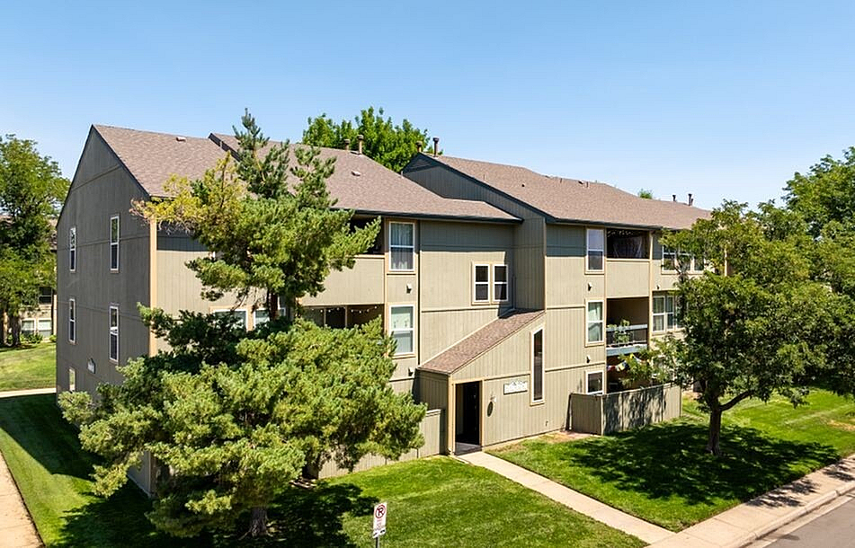 Charming apartment building with lush greenery and a serene suburban vibe; perfect for modern living.