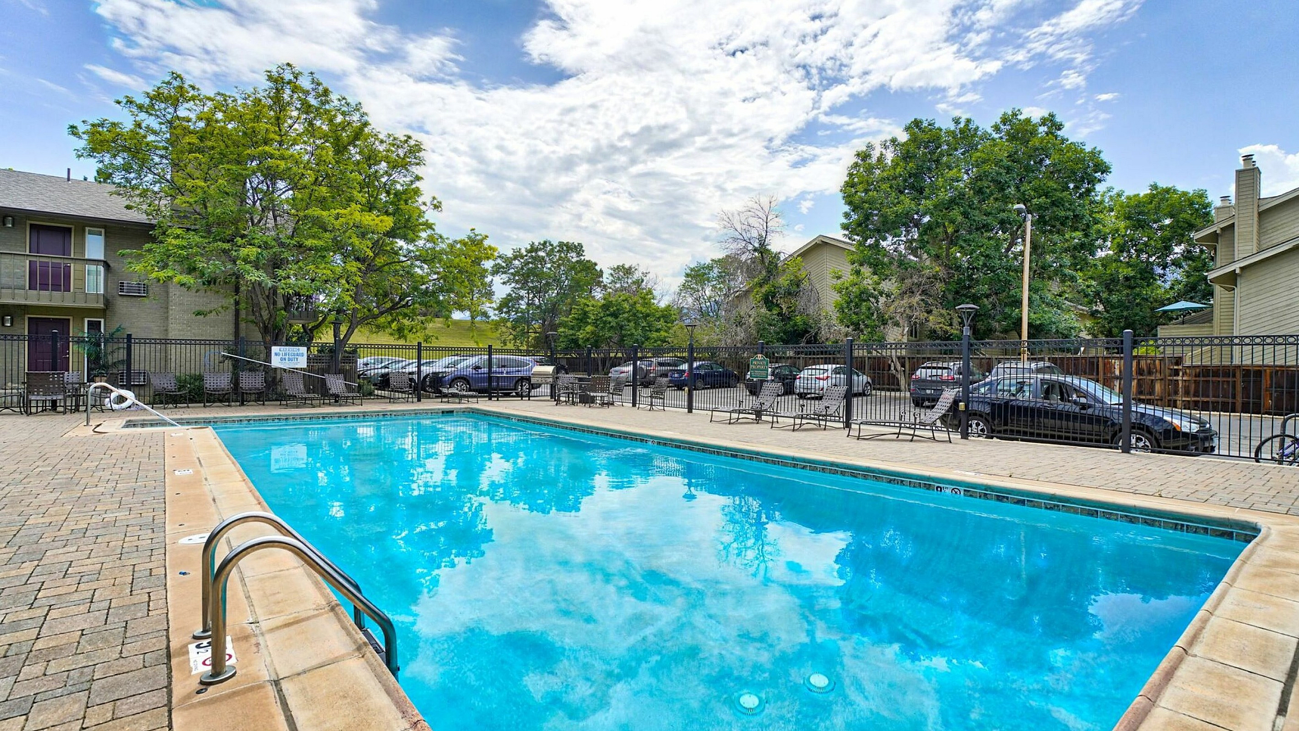 Inviting outdoor pool area surrounded by lush greenery, perfect for relaxation and leisure.