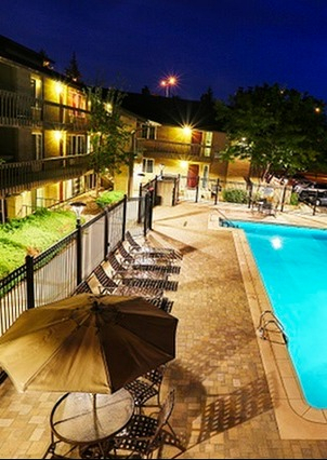 Luxurious outdoor pool area illuminated at night with inviting lounge chairs and umbrellas for relaxation.