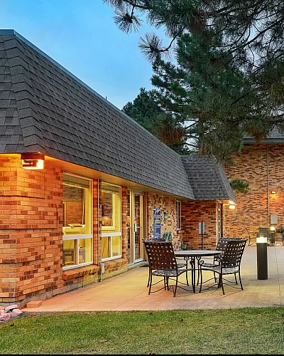 Charming outdoor space featuring a cozy patio with stylish seating, a beautifully landscaped lawn, and a glistening pool, perfect for relaxation and entertainment.
