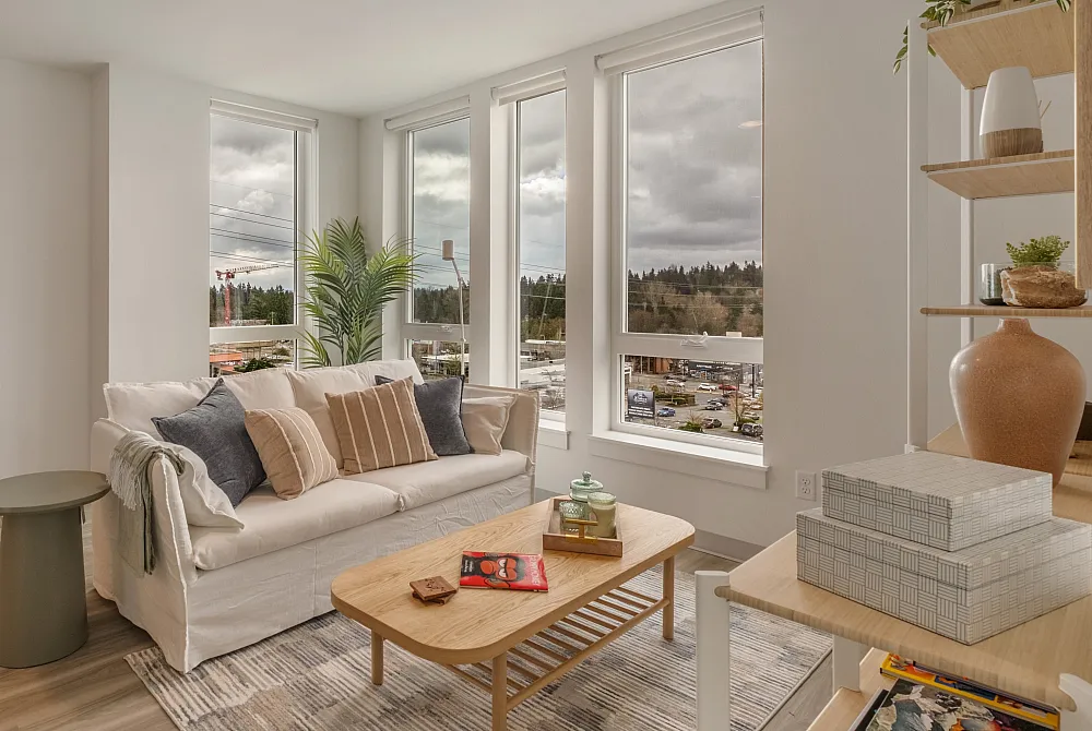 Bright living room at The Nook at Northaven featuring large windows, modern furnishings, and natural light.