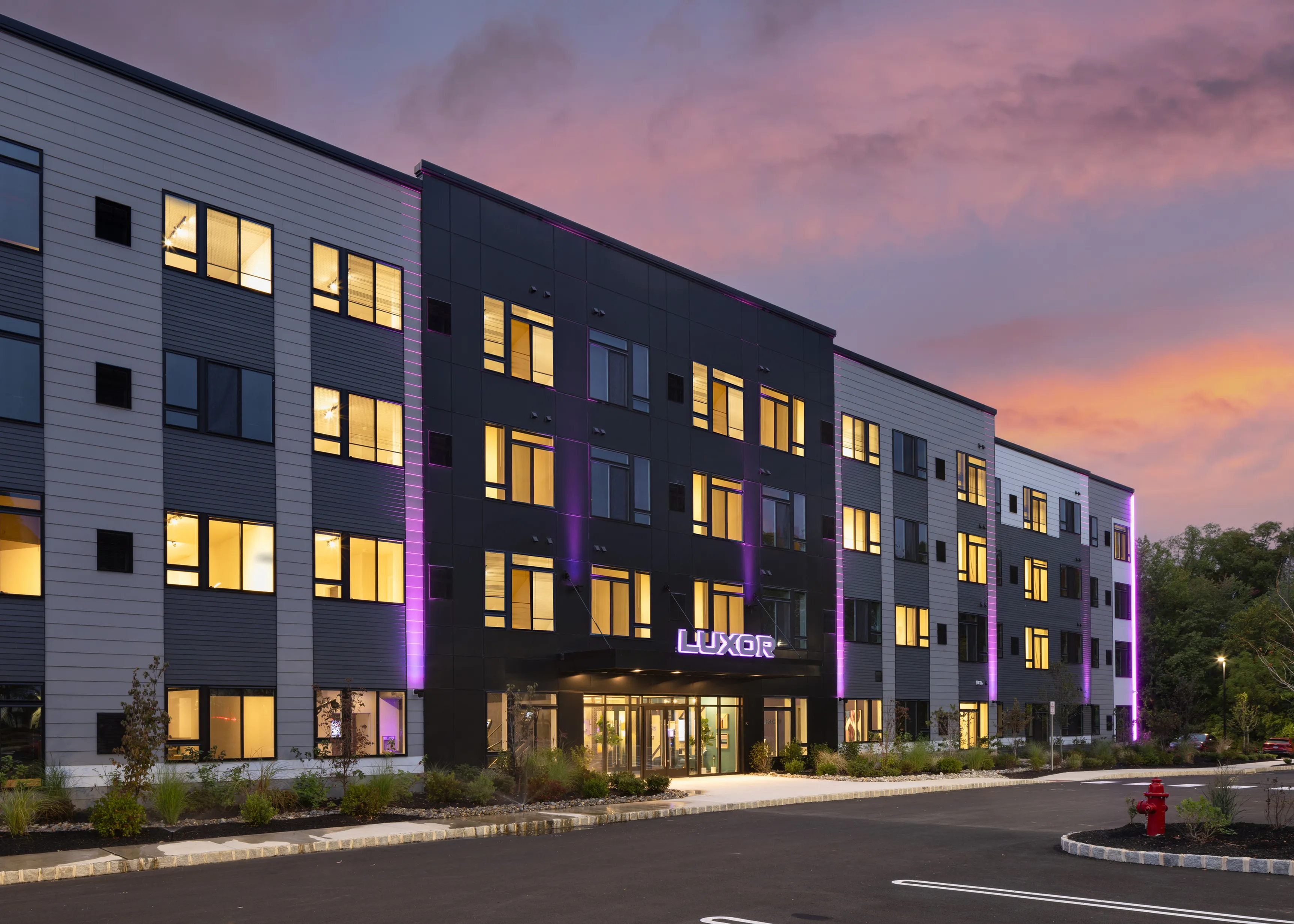 Luxor Montgomeryville's modern apartment building with purple lights and