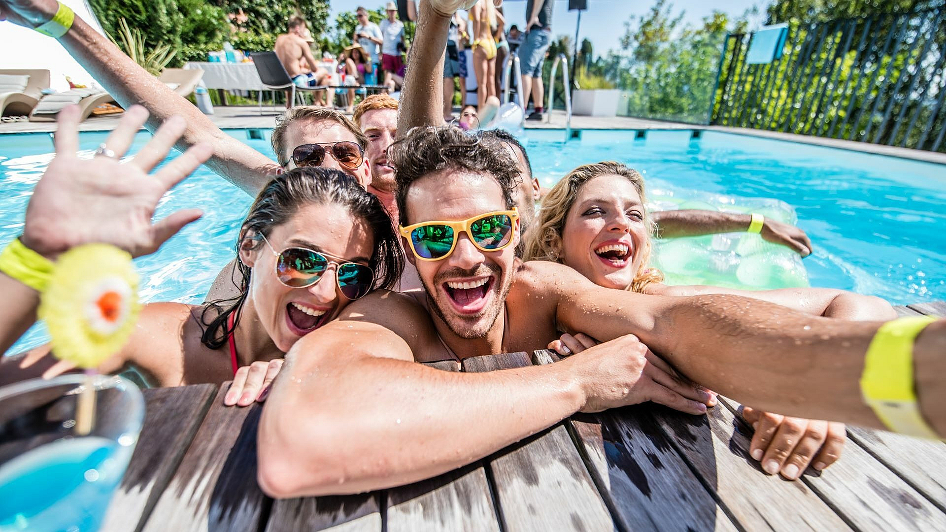 Vibrant poolside fun with friends enjoying a sunny day, showcasing luxury amenities and lively atmosphere.