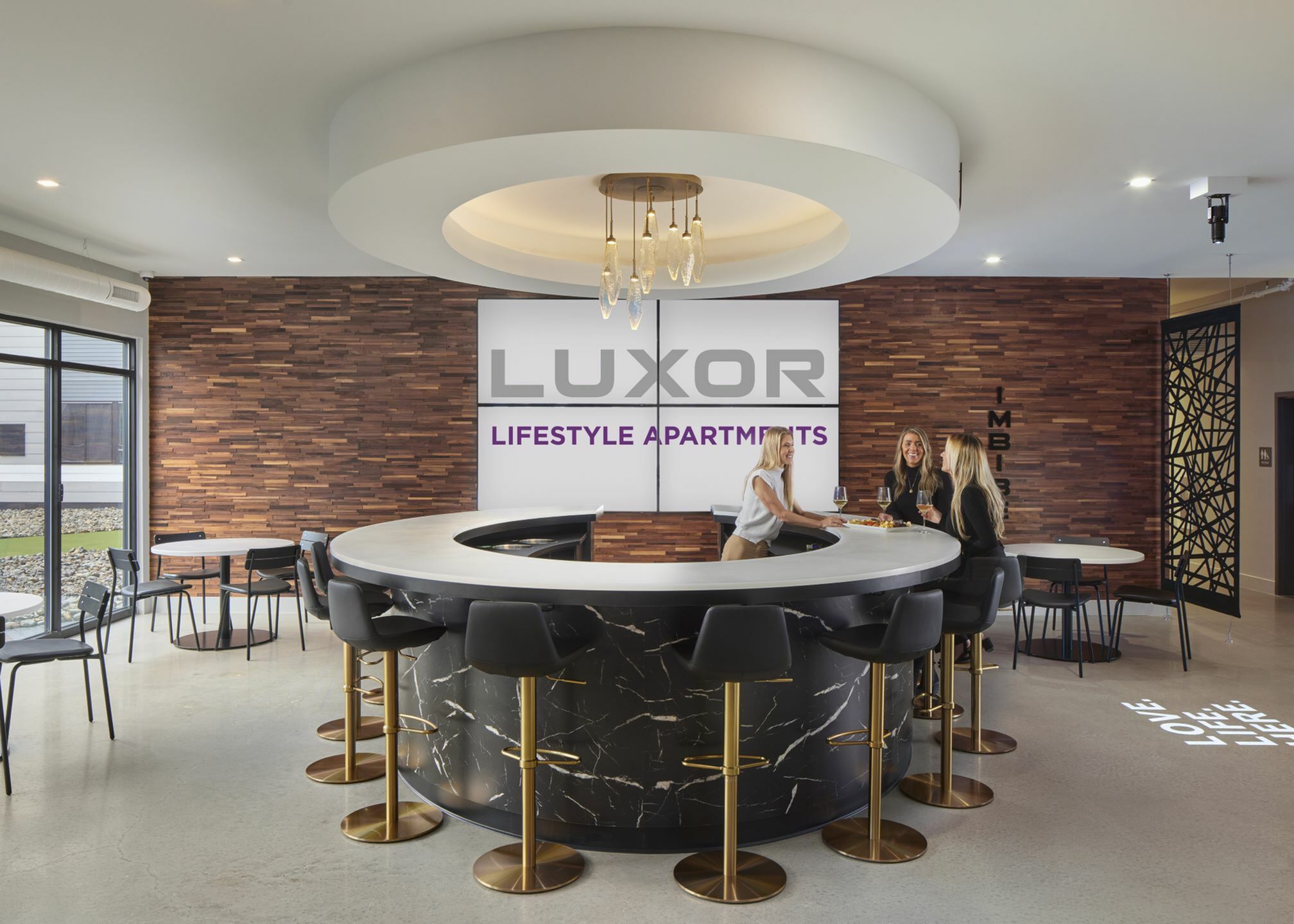 Luxor Lifestyle Apartments lounge showcasing a chic circular bar with elegant lighting and modern seating.