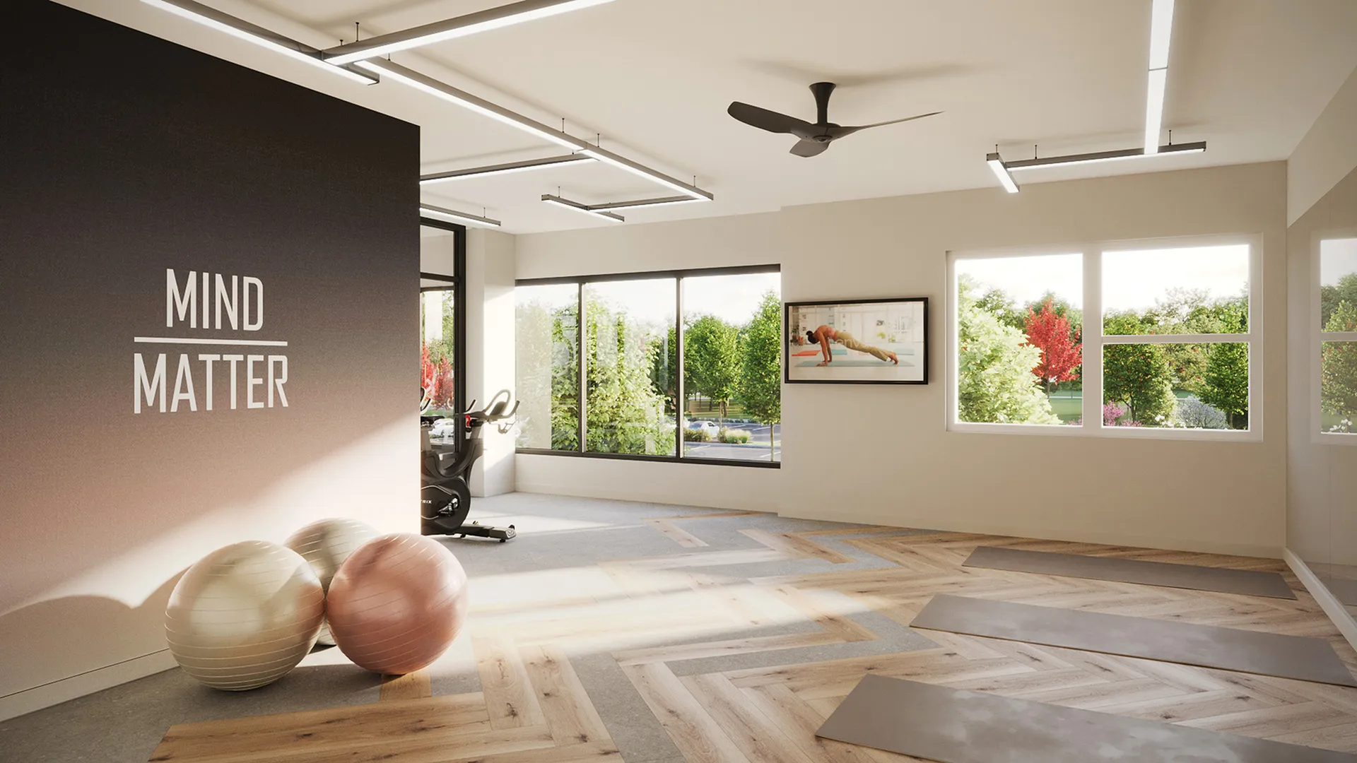Bright and modern home gym with large windows, yoga mats, exercise balls, and motivational decor.