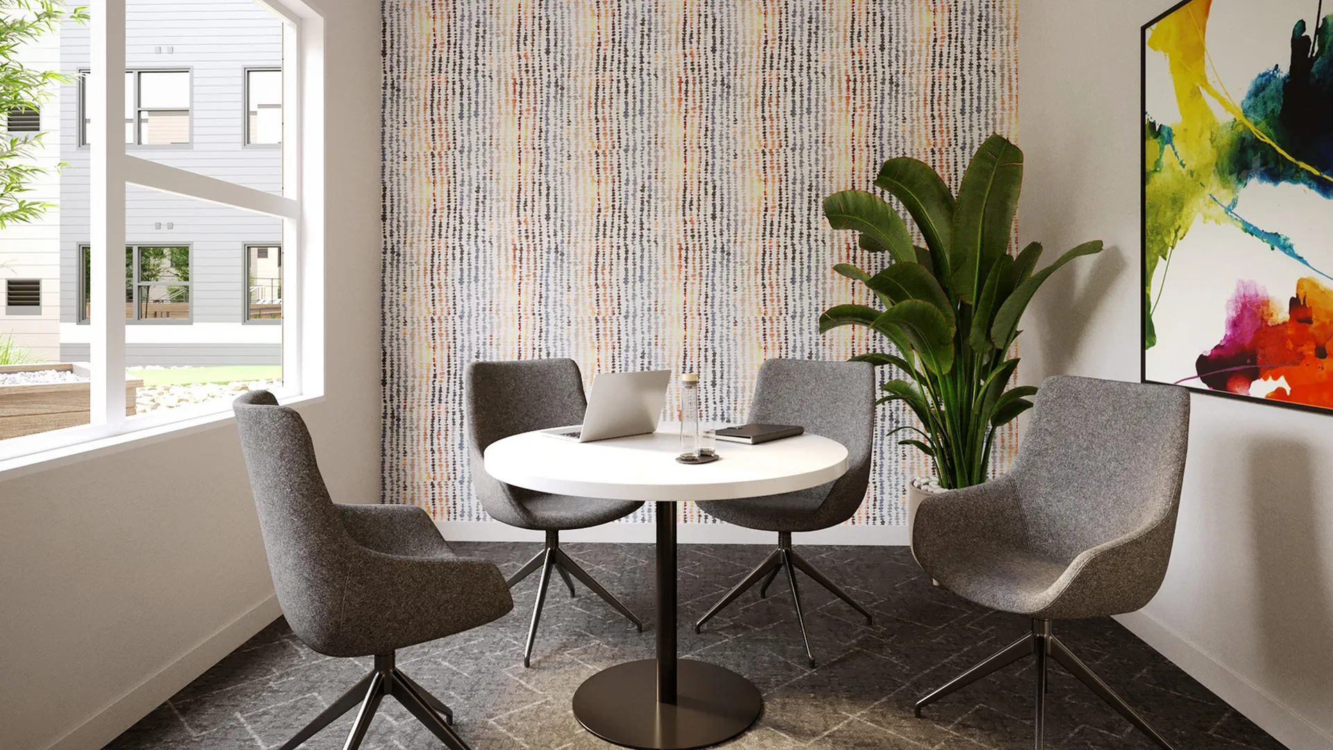 Chic dining area with modern gray chairs, a round table, and vibrant artwork, offering a stylish and serene atmosphere.