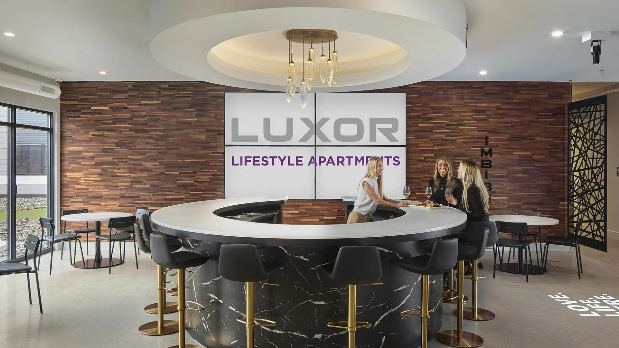 Luxor Lifestyle Apartments lounge area featuring a stylish circular bar with elegant lighting and modern decor.