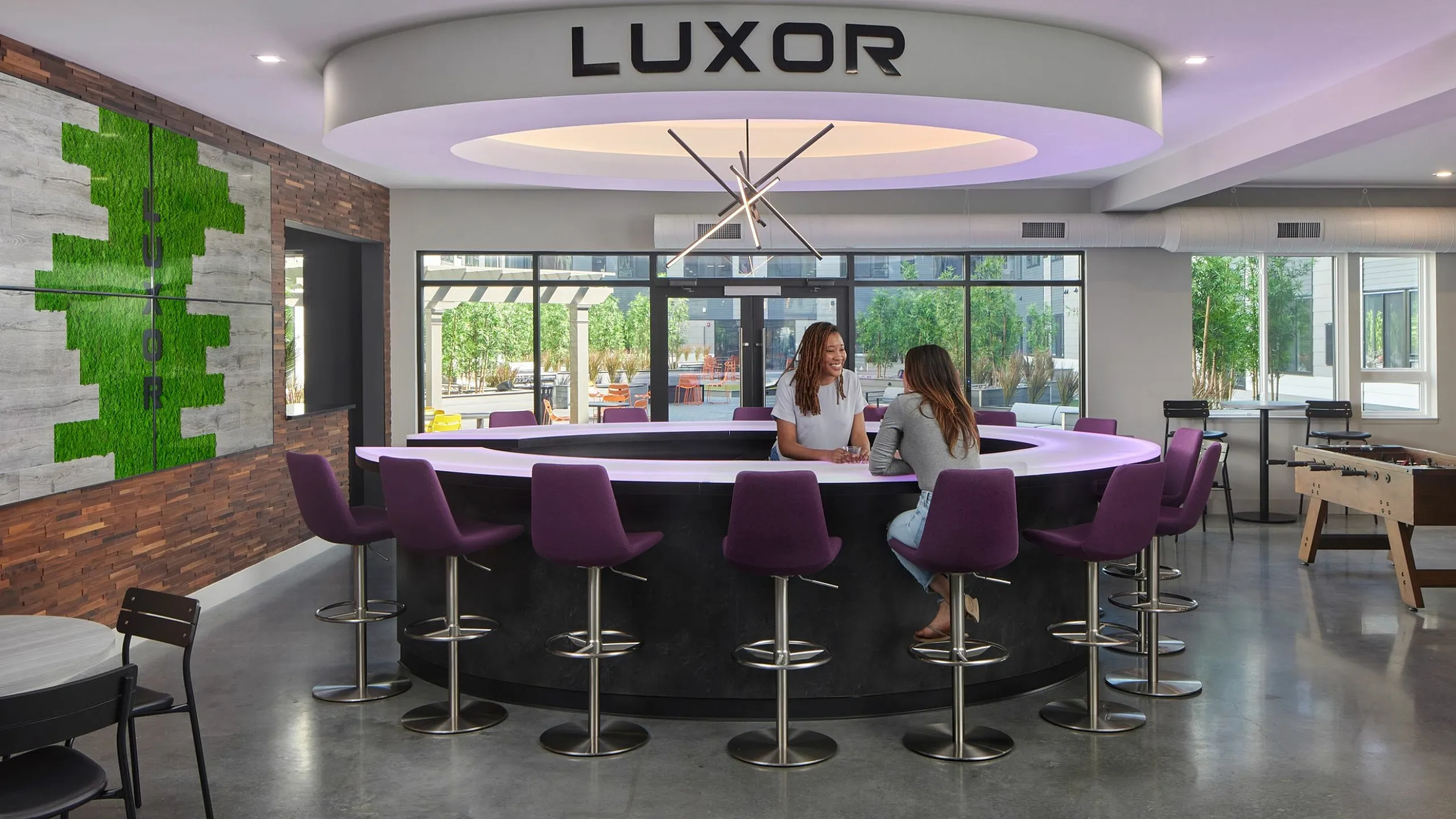 Luxor apartment lounge with modern design, vibrant purple seating, and inviting social ambiance.