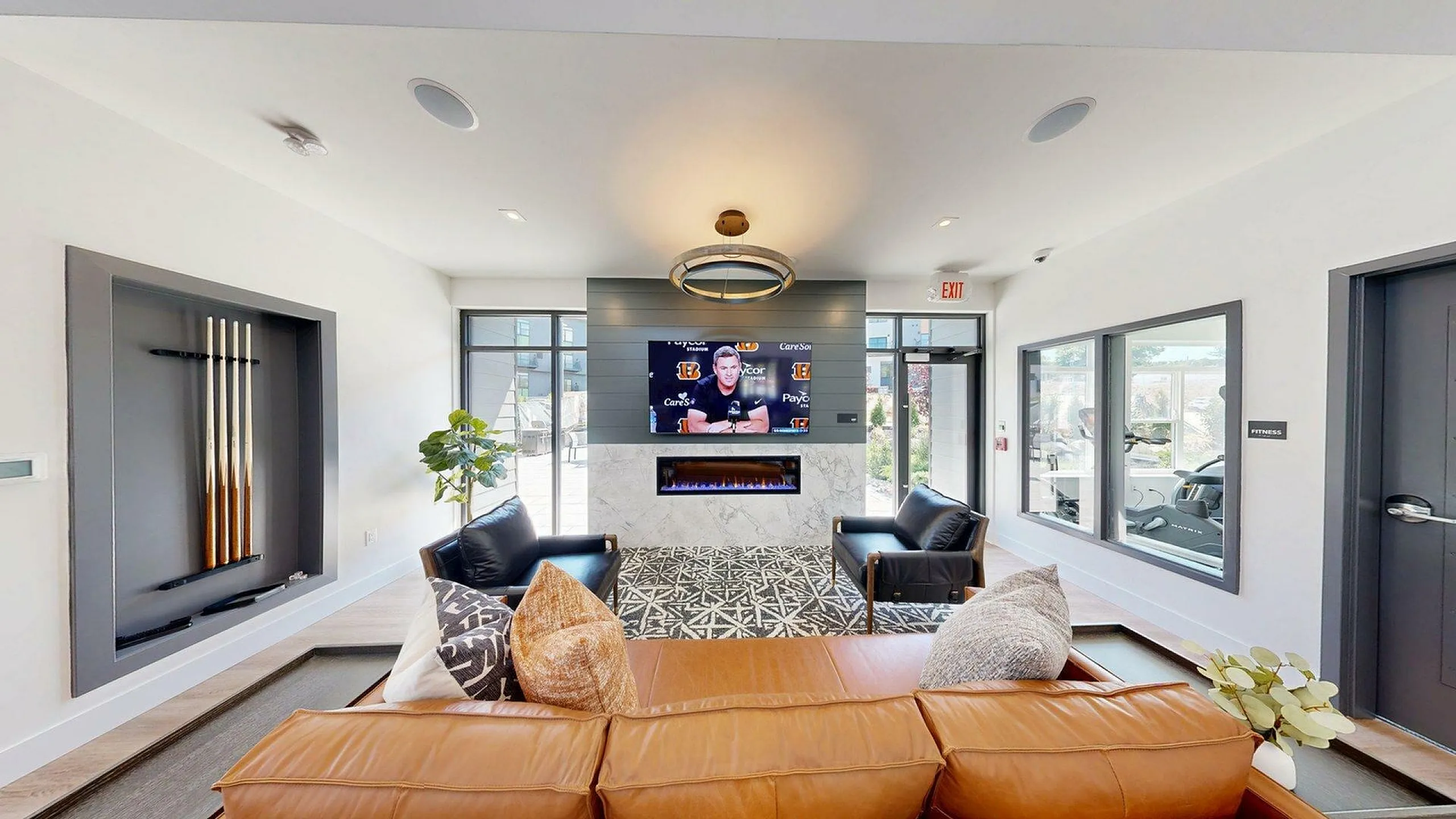 Modern lounge area with stylish leather seating, elegant wall decor, and a sleek fireplace, perfect for relaxation and entertainment.