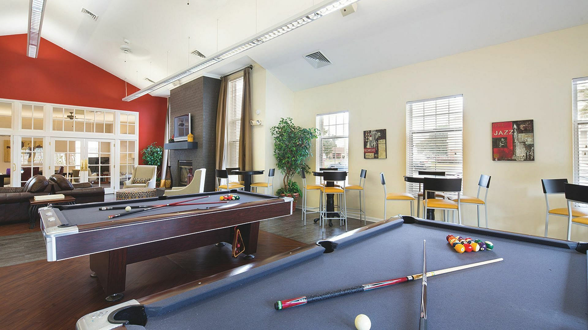 Stylish recreational lounge featuring pool tables, modern seating, and vibrant decor.