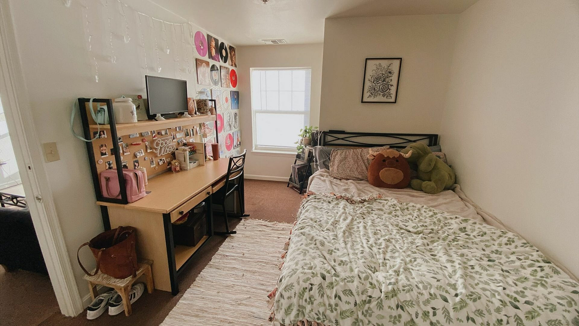 Inviting bedroom with a desk, charming decor, and plush bedding.