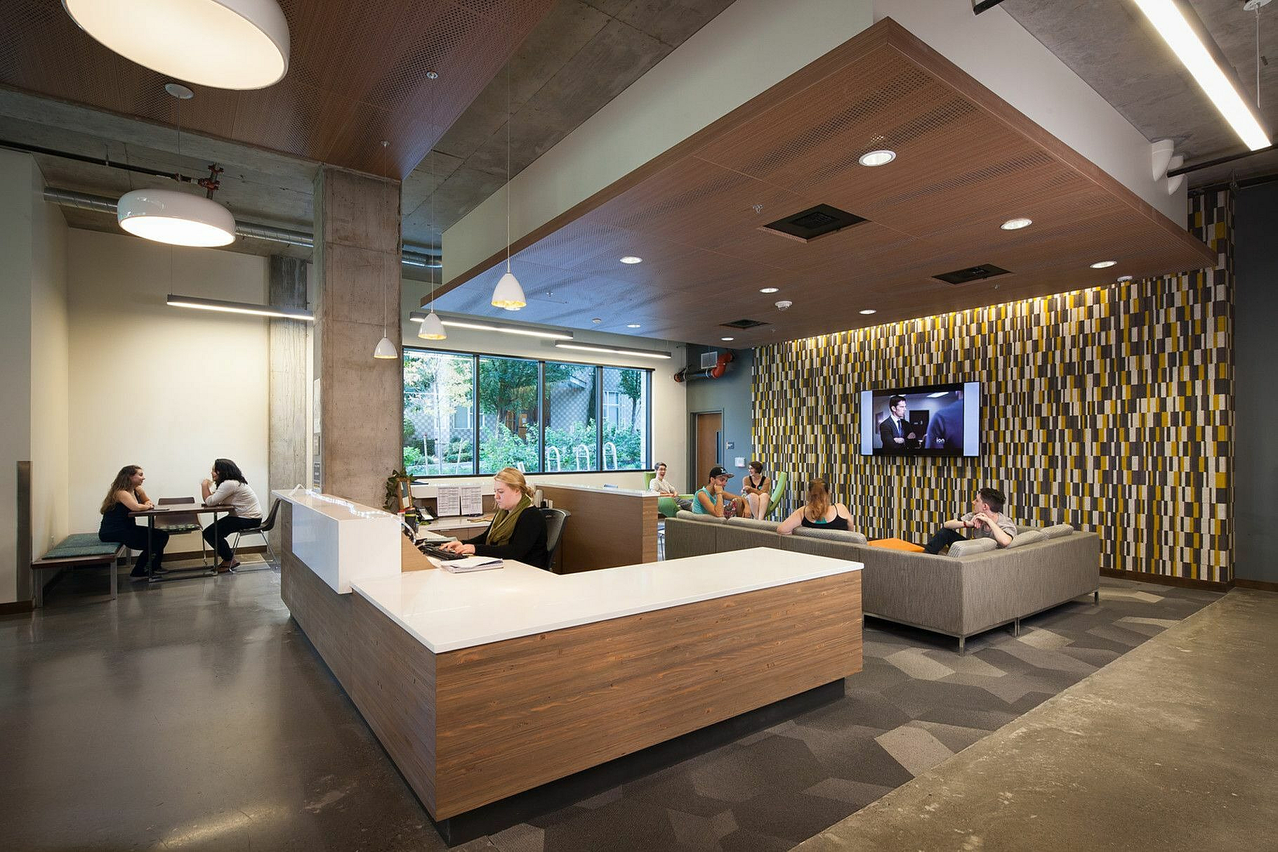 Modern lobby area featuring stylish seating, contemporary design, and a welcoming reception desk, perfect for relaxation and social interaction.