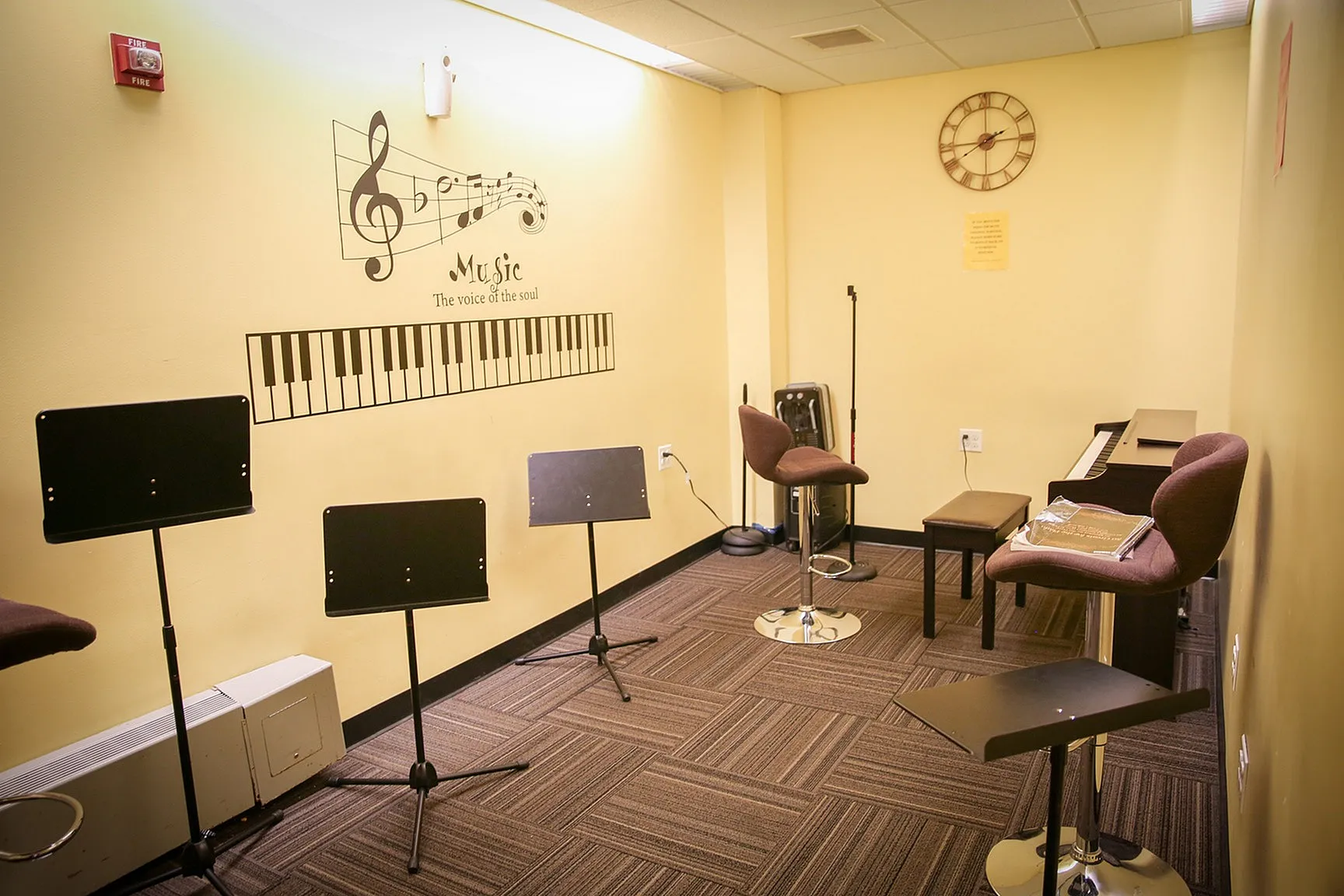 Inviting music practice room with a piano, music stands, and comfortable seating, complemented by inspiring wall art.