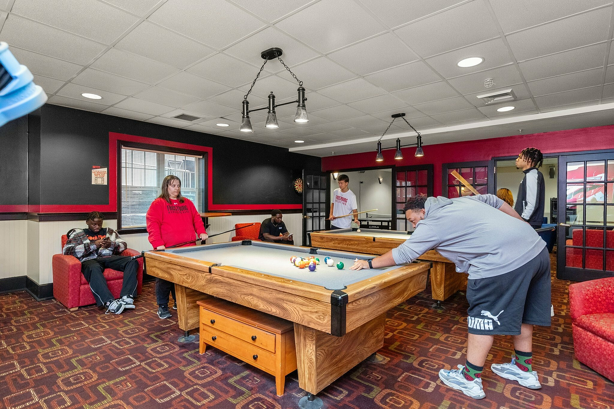 Vibrant game room with a pool table and stylish seating area, perfect for entertainment and relaxation.