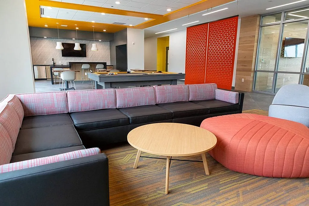 Modern open-concept living space featuring vibrant decor, a cozy sectional sofa, and a stylish gaming area with a pool table.