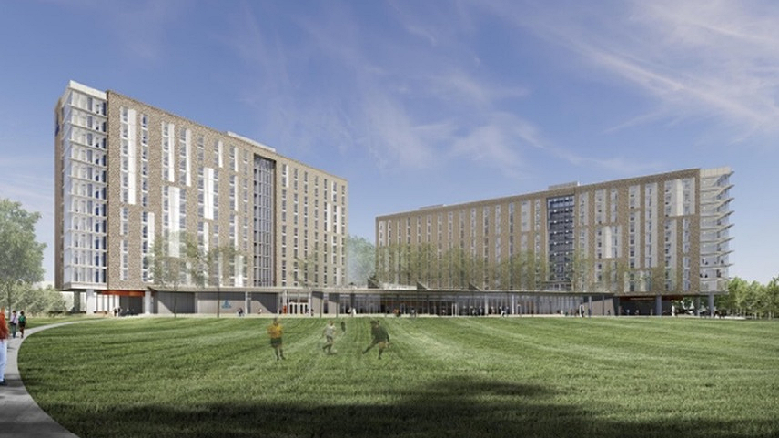Contemporary apartment complex with two tall buildings and a lush green lawn under a clear blue sky.