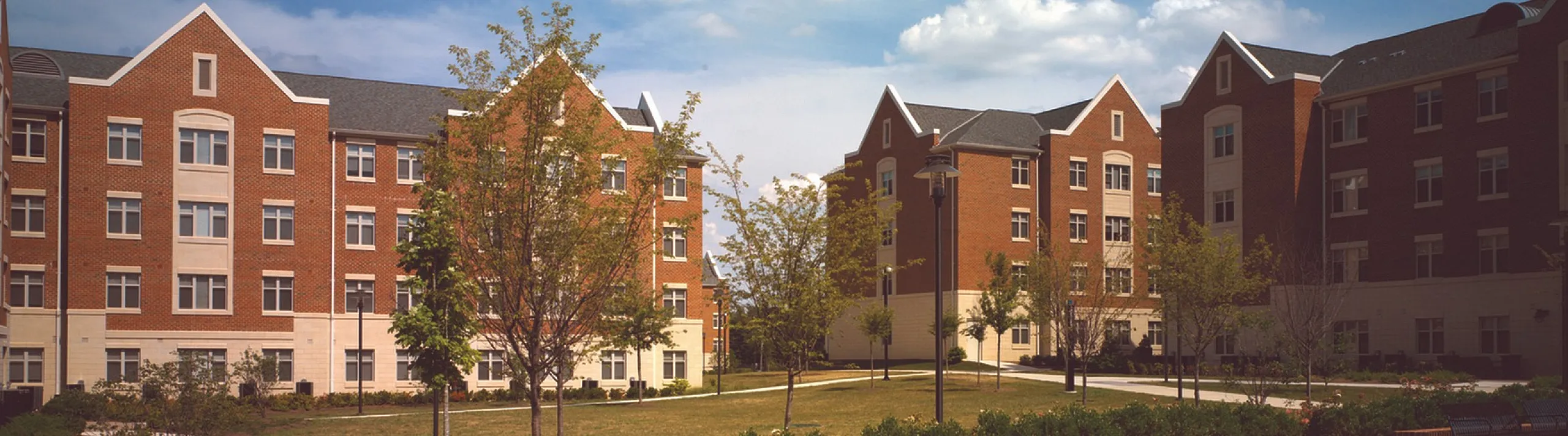 Charming residential buildings with red brick facade under a vibrant blue sky.