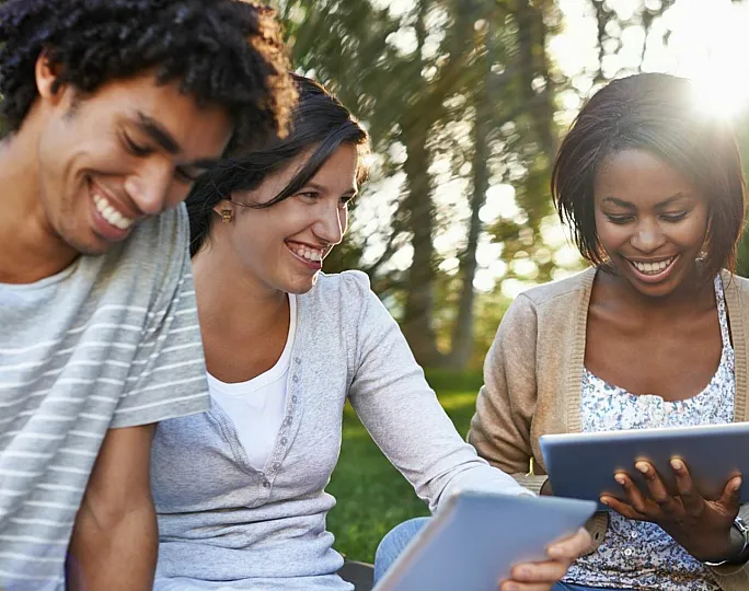 Vibrant group of friends enjoying technology together outdoors, depicting joyful connections and shared digital experiences.