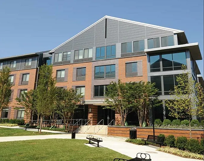 Charming modern apartment building with sleek design and lush landscaping, offering a welcoming and vibrant living environment.
