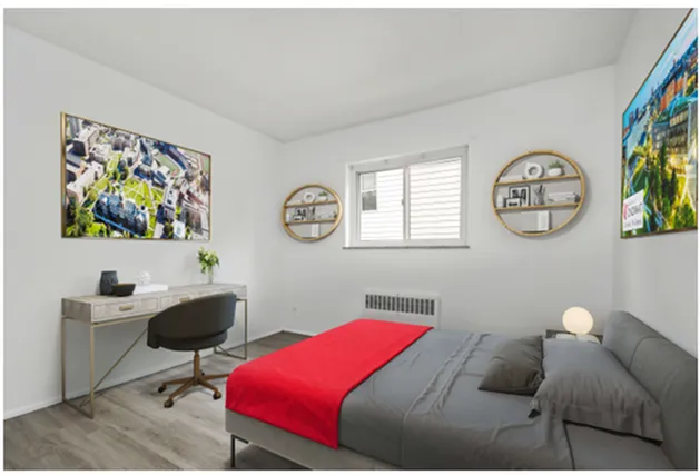 Modern bedroom with stylish decor, featuring a workspace, artwork, and a cozy bed.