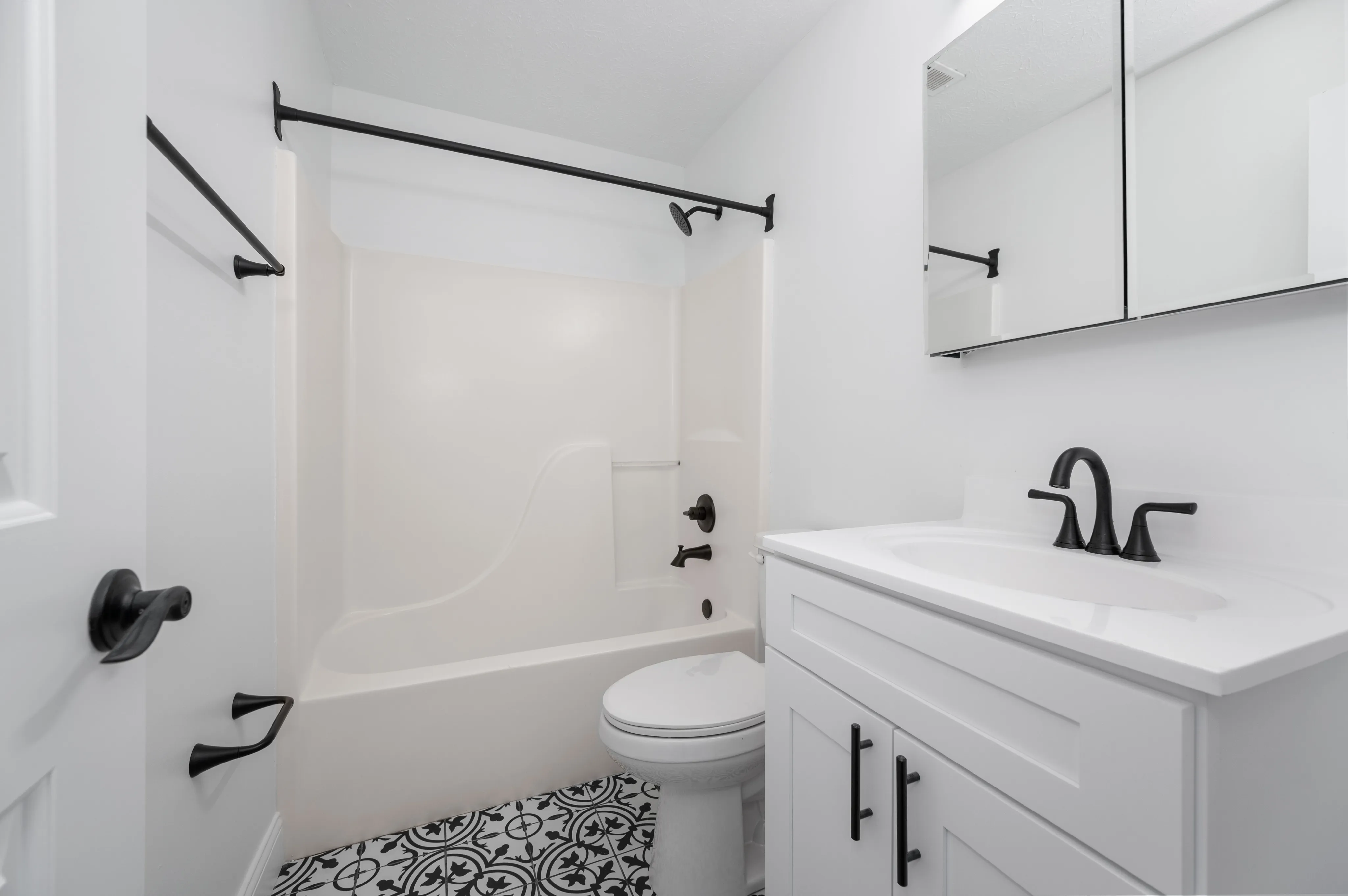 Modern bathroom featuring elegant fixtures and stylish patterned tile flooring.