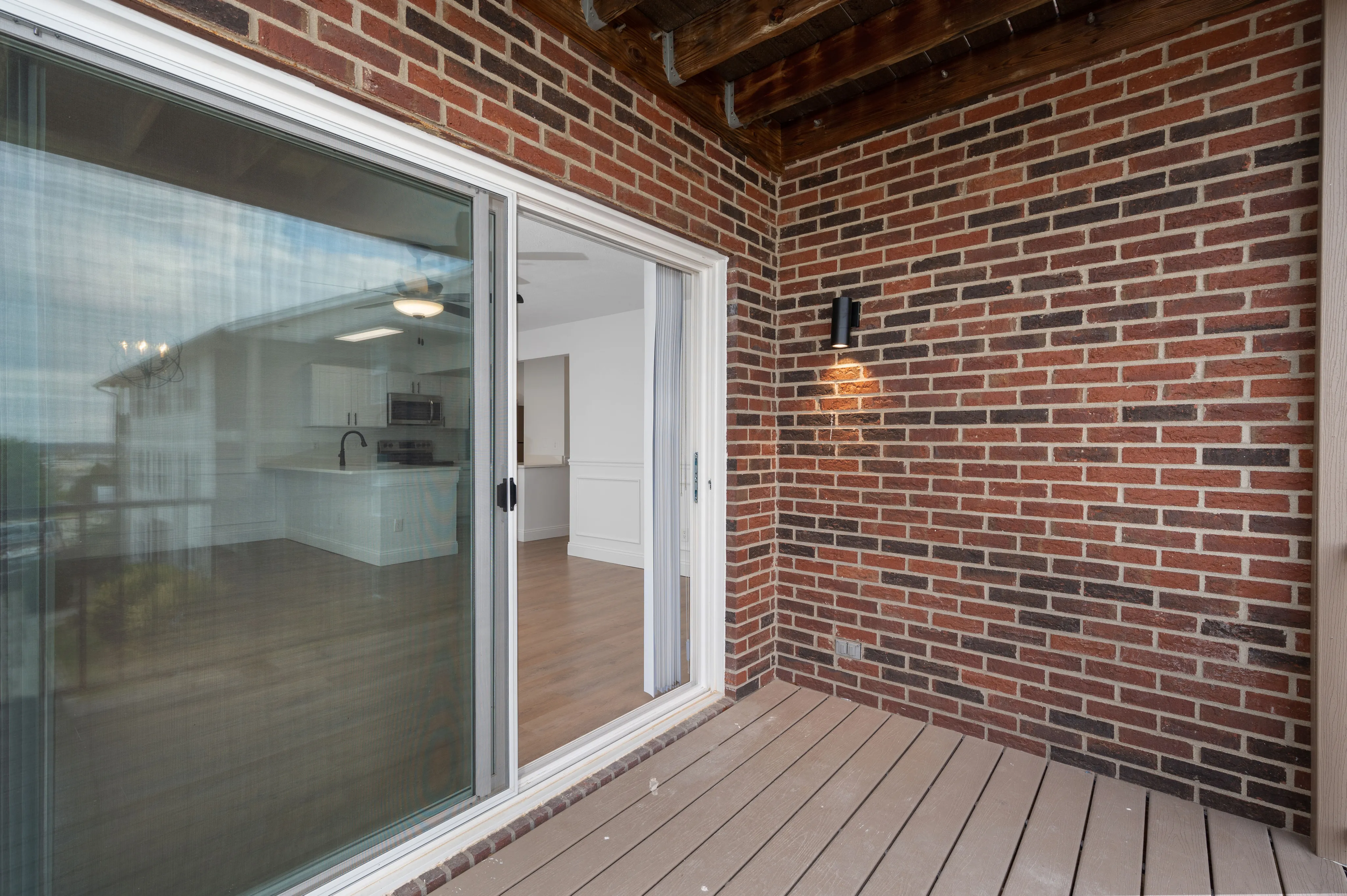 Inviting brick patio with sliding glass doors opening to a modern interior.