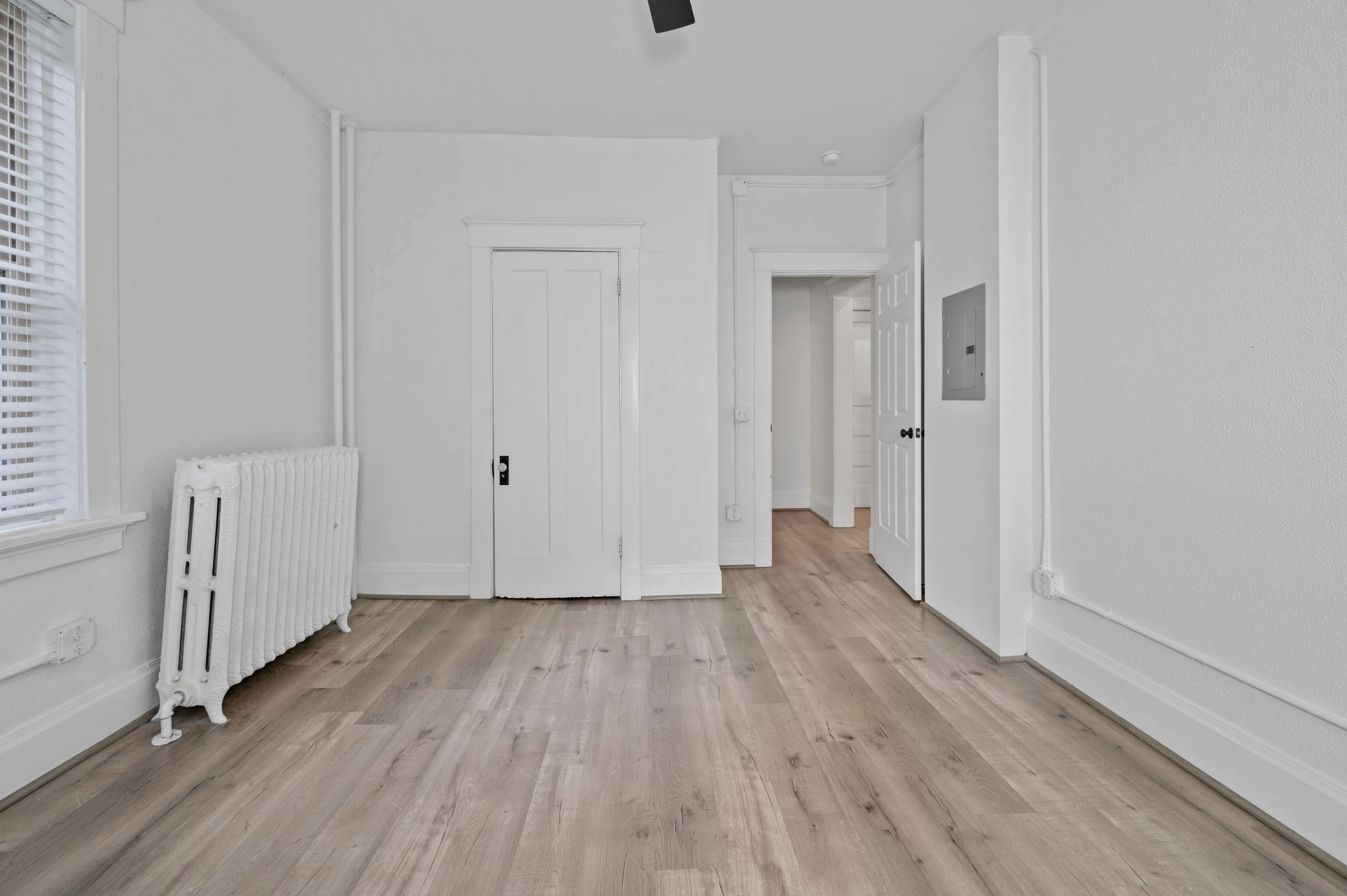 Bright and inviting room with light wood flooring and classic white radiator, perfect for a cozy living space.