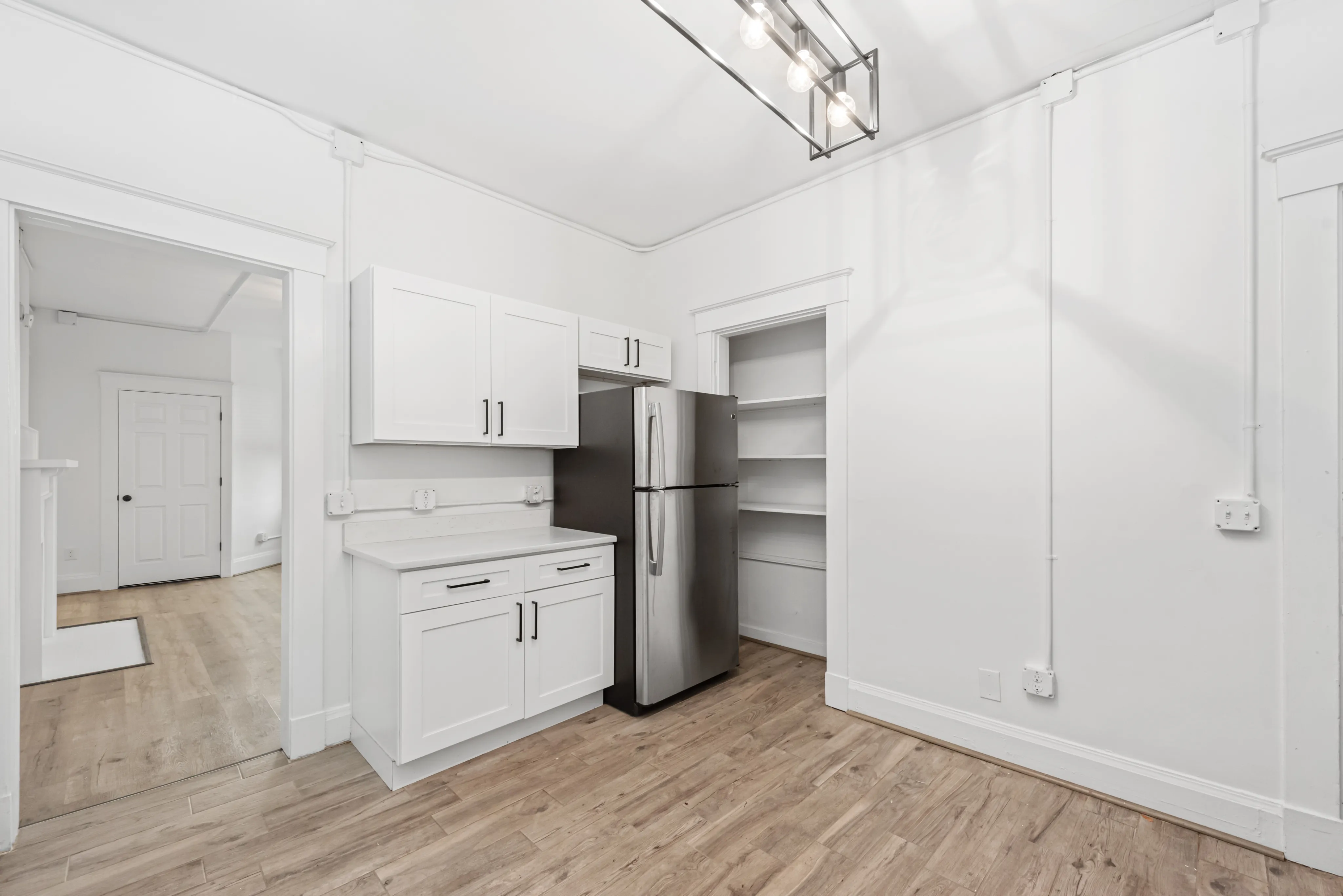 Modern kitchen space with sleek stainless steel appliances, chic white cabinetry, and stylish lighting, perfect for culinary creativity.