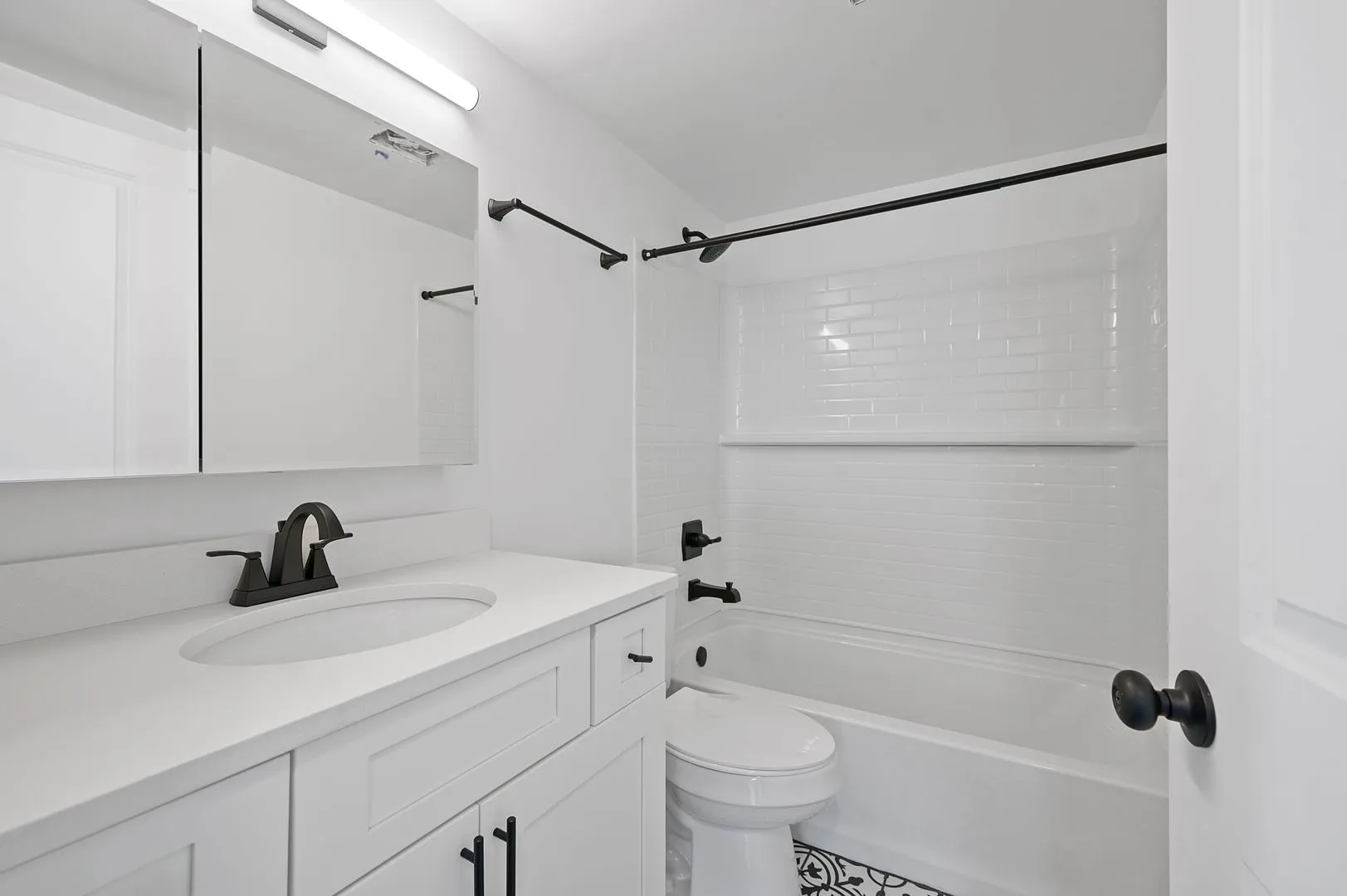 Elegant modern bathroom with sleek white cabinetry, glossy tiles, and stylish matte black fixtures.