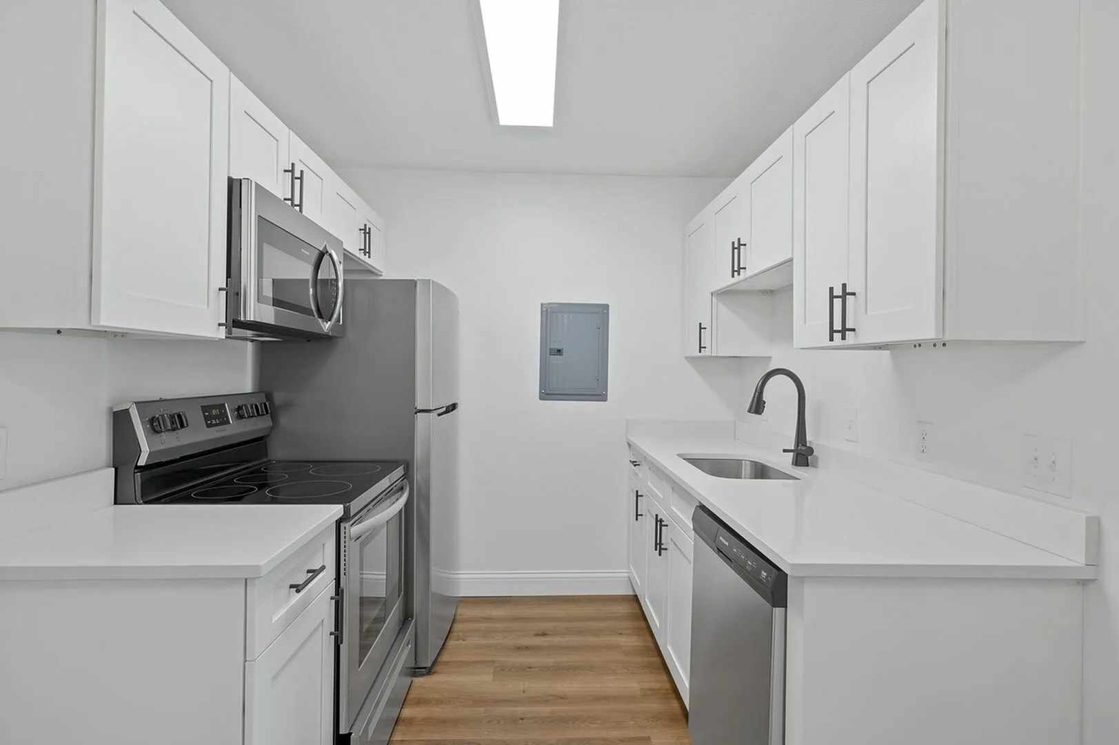 Modern kitchen with sleek stainless steel appliances, white cabinetry, and elegant countertops, offering a stylish and functional space for cooking.