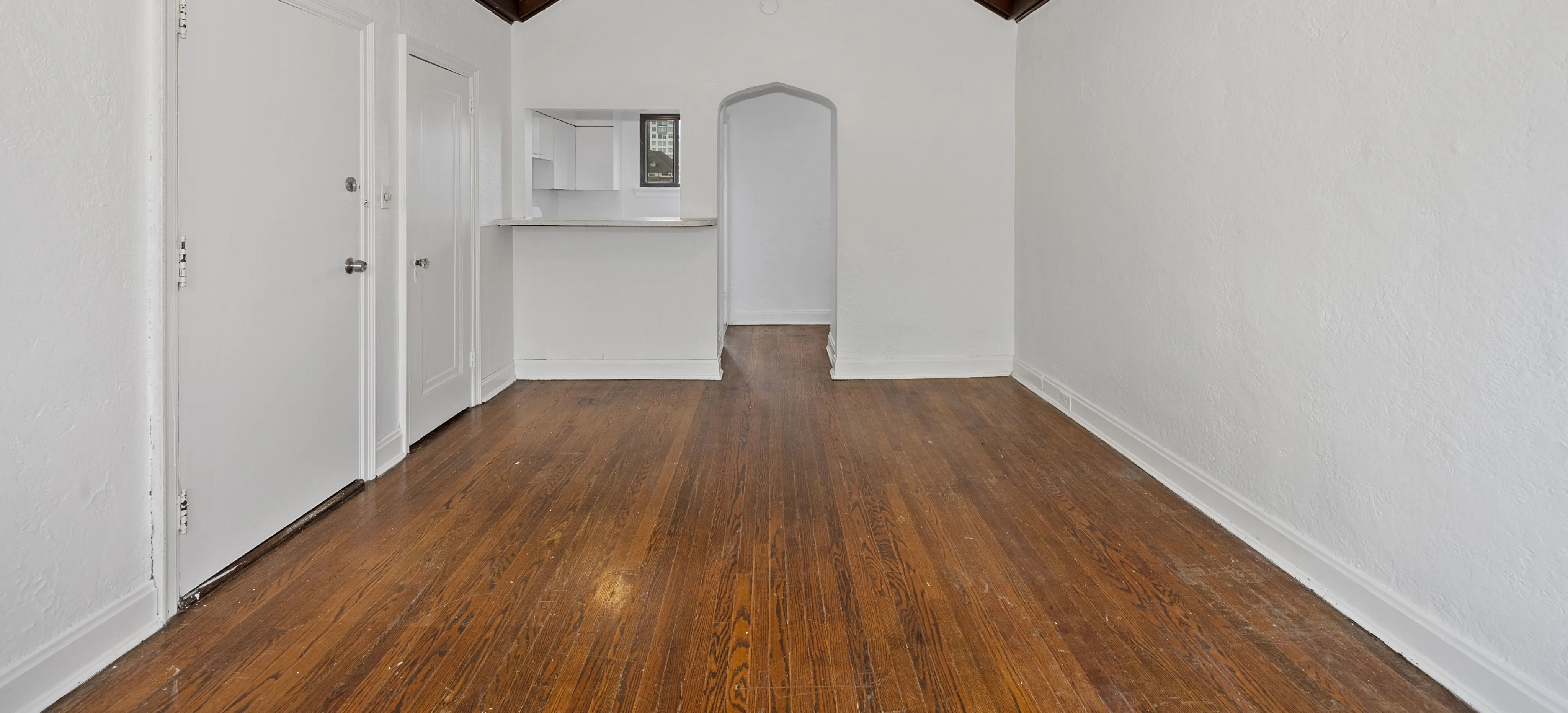 Charming apartment space featuring elegant hardwood floors and a cozy breakfast bar, perfect for modern living.