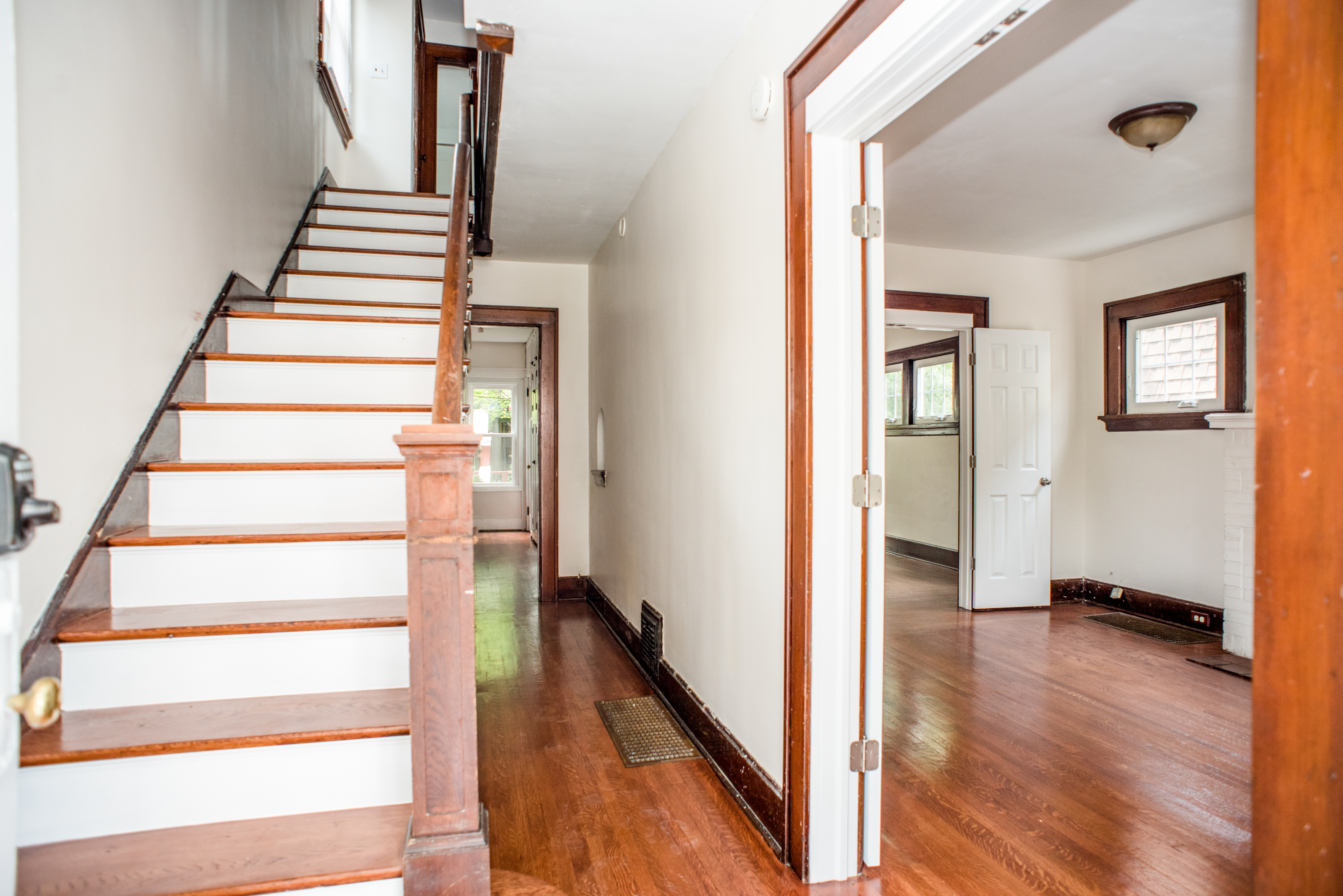 Inviting hardwood staircase leading to a bright corridor with rich wooden accents and gleaming floors.