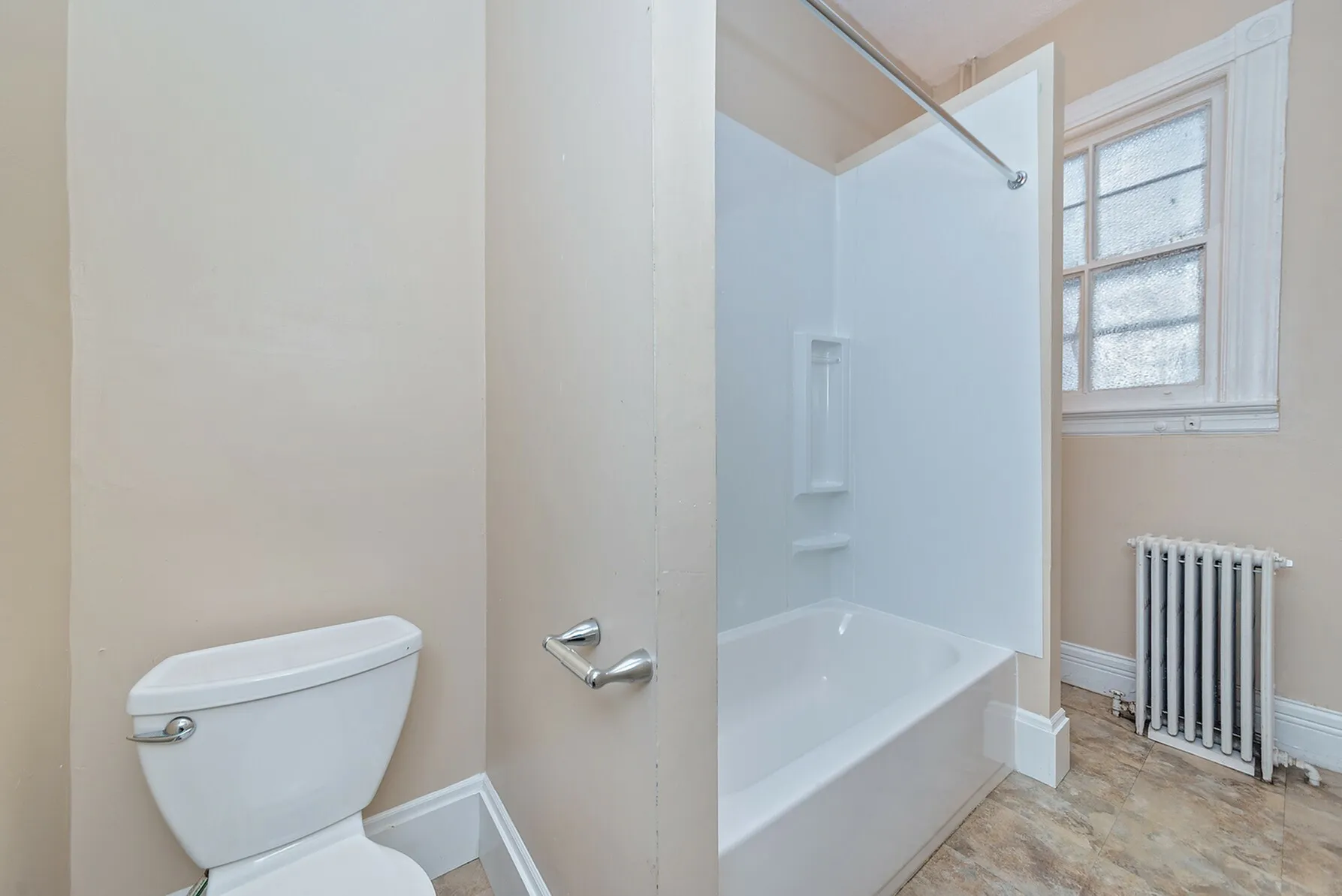 Bright and inviting bathroom with modern tub-shower combo and natural light from a frosted window.