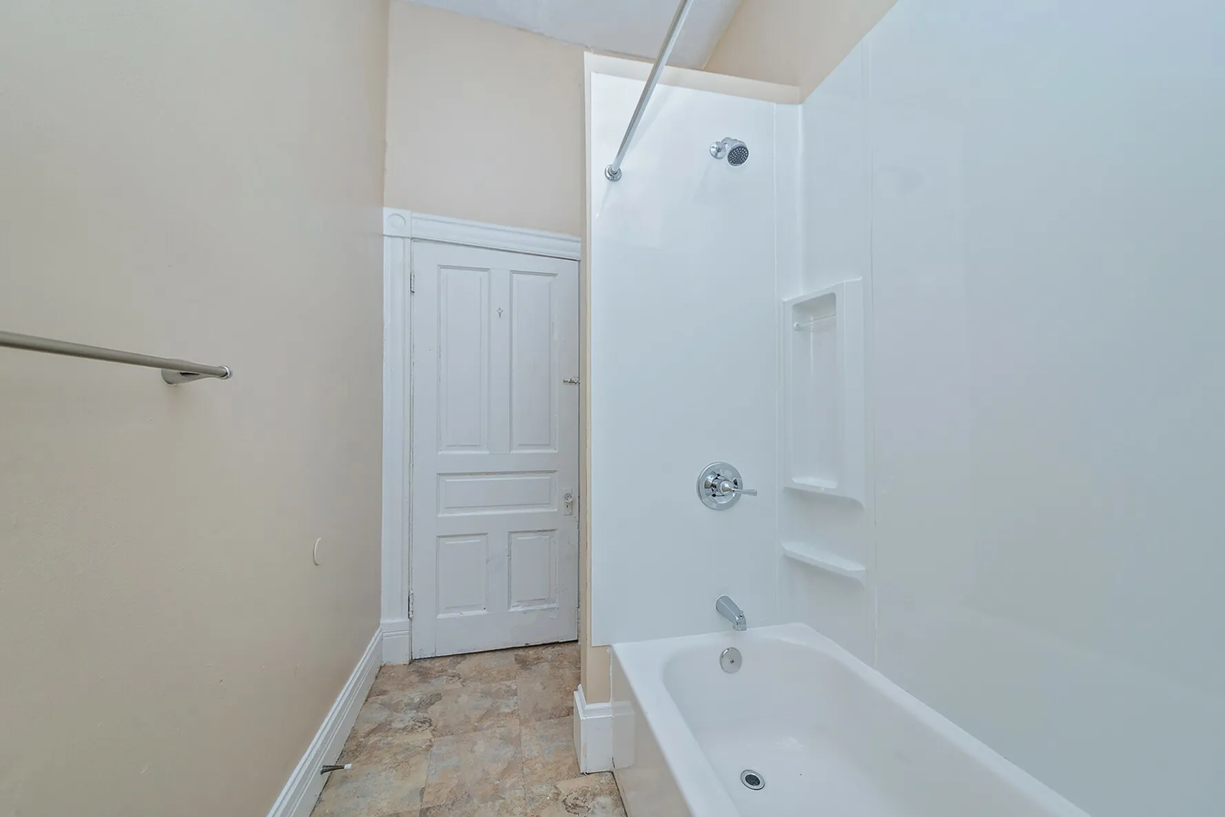 Modern bathroom with white bathtub and bright accents, featuring sleek fixtures and elegant tiling.