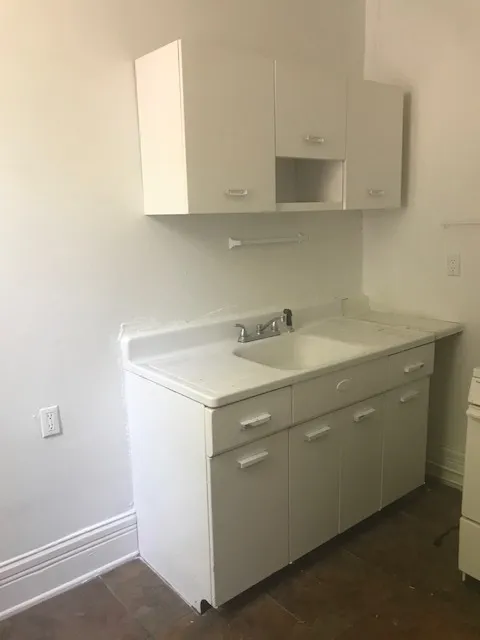 Charming kitchen corner featuring a classic white cabinet and sink ensemble with ample storage space.
