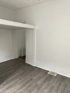 Bright and airy room with elegant wood flooring and fresh white walls, perfect for creative interior design.