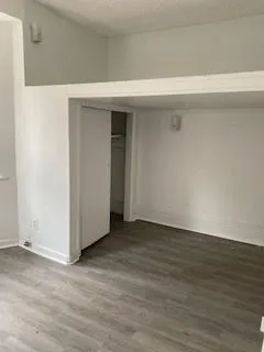 Bright and modern apartment corner with wood flooring, featuring a cozy nook and entryway.