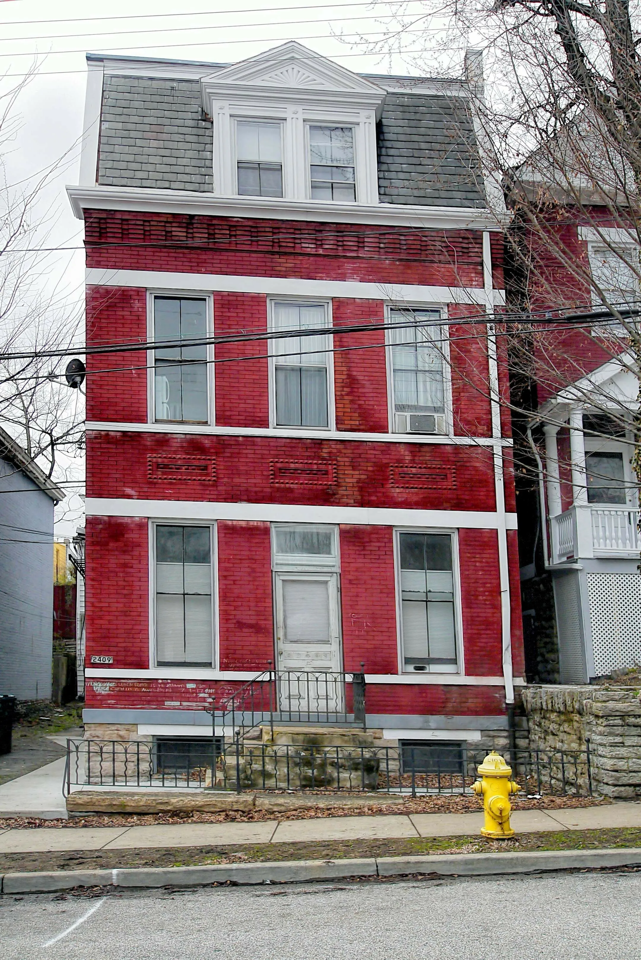 Charming red brick townhouse featuring classic architectural details and inviting curb appeal, perfect for urban living.