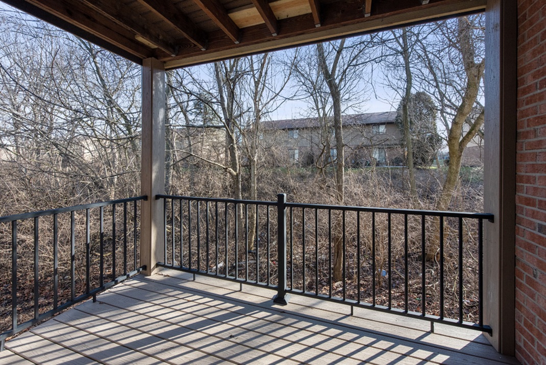Charming balcony with rustic wood accents and tranquil forest view, perfect for relaxation.