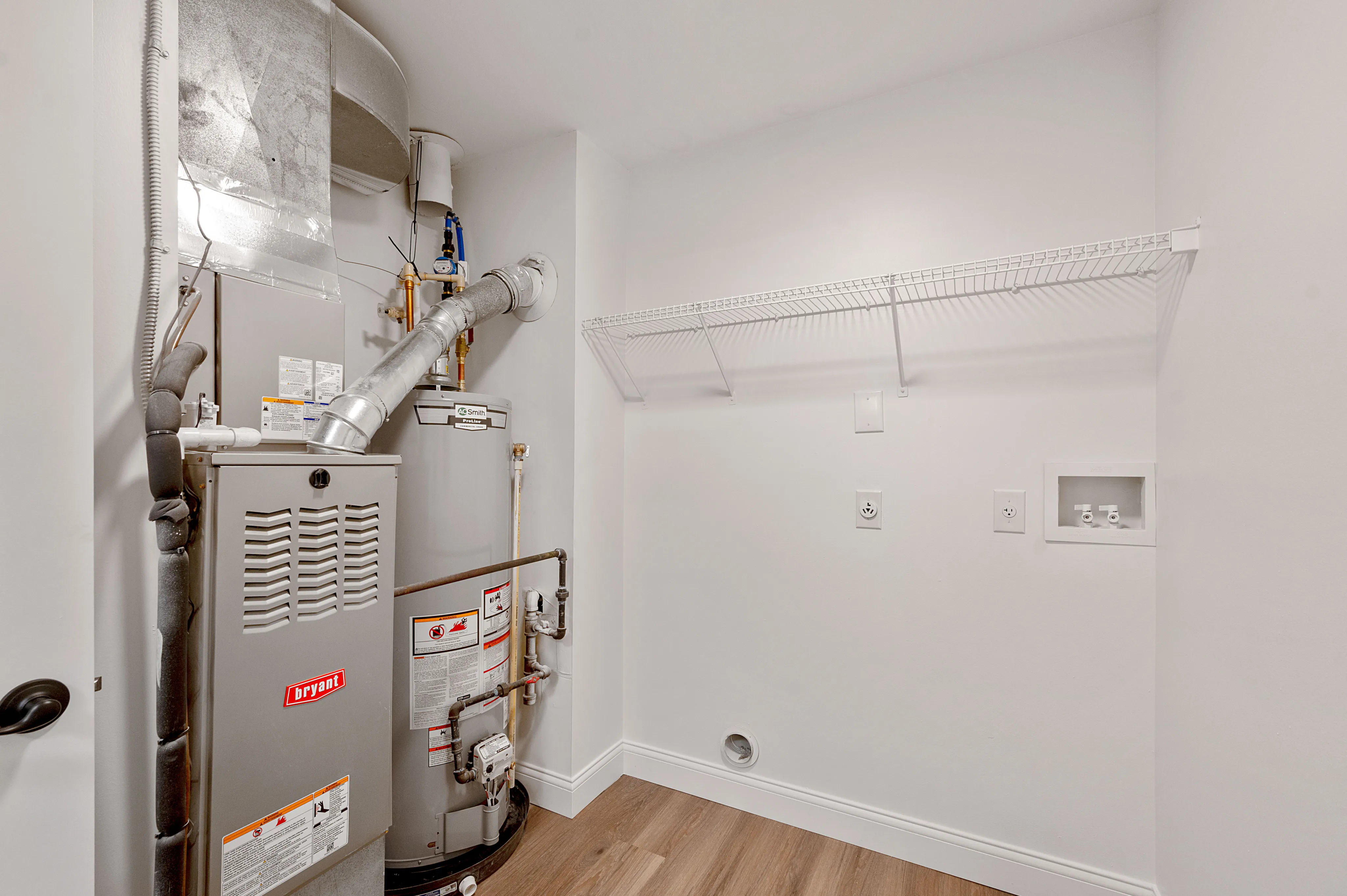 Utility room with modern HVAC system and ample shelving space, offering efficient home climate control and convenience.