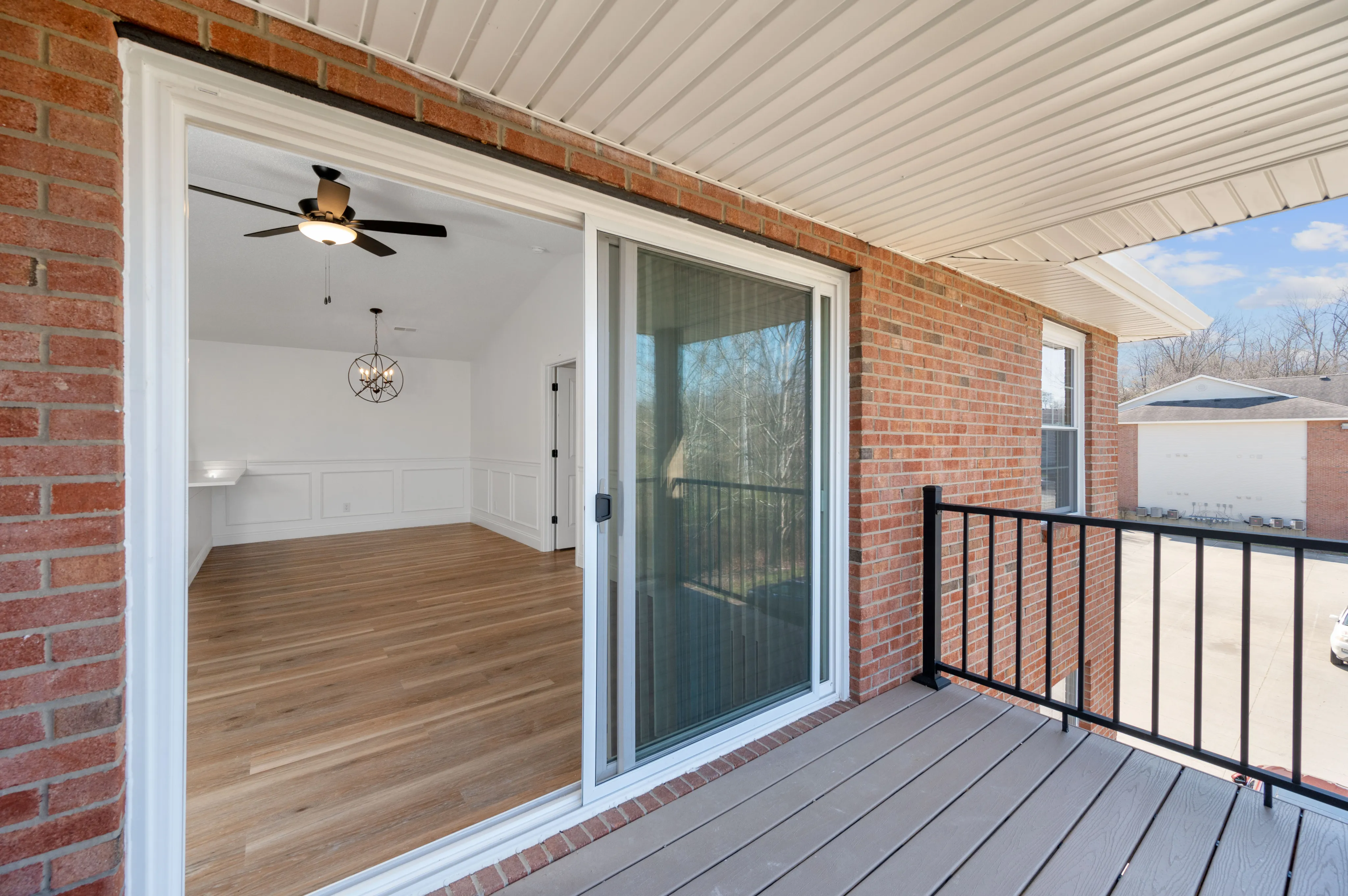 Inviting balcony view showcasing a modern, stylish living area with elegant lighting and chic wood flooring.