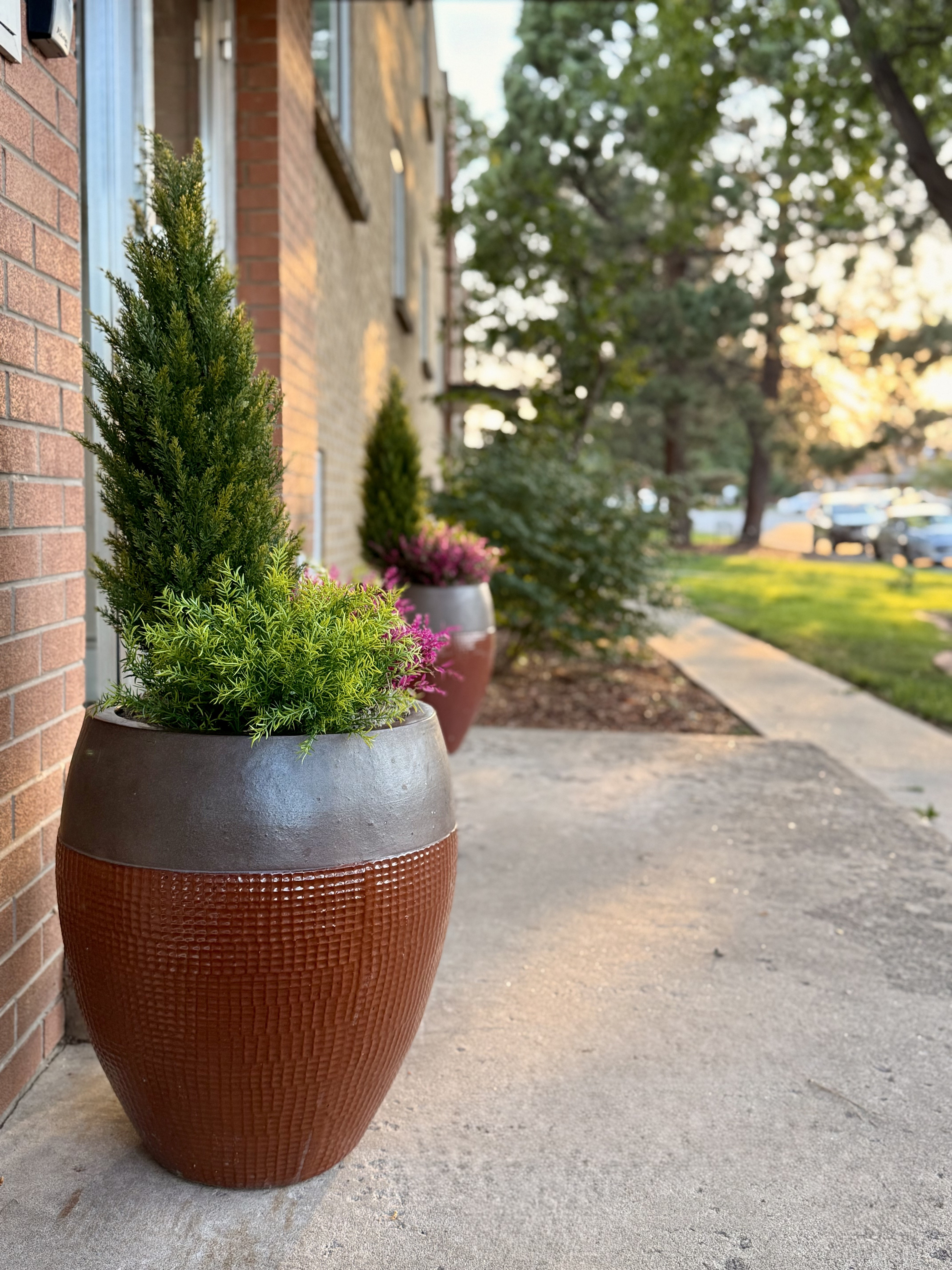 Charming apartment exterior with elegant planters, lush greenery, and a scenic view of the tranquil neighborhood.