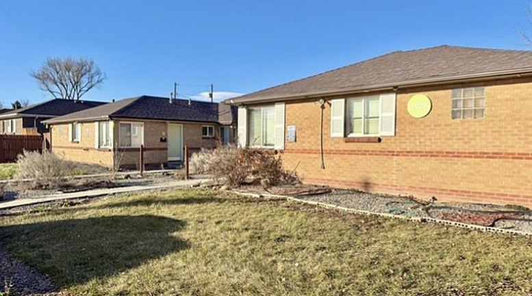 Charming brick duplex with large windows, nestled in a sunny, landscaped yard offering a welcoming suburban vibe.
