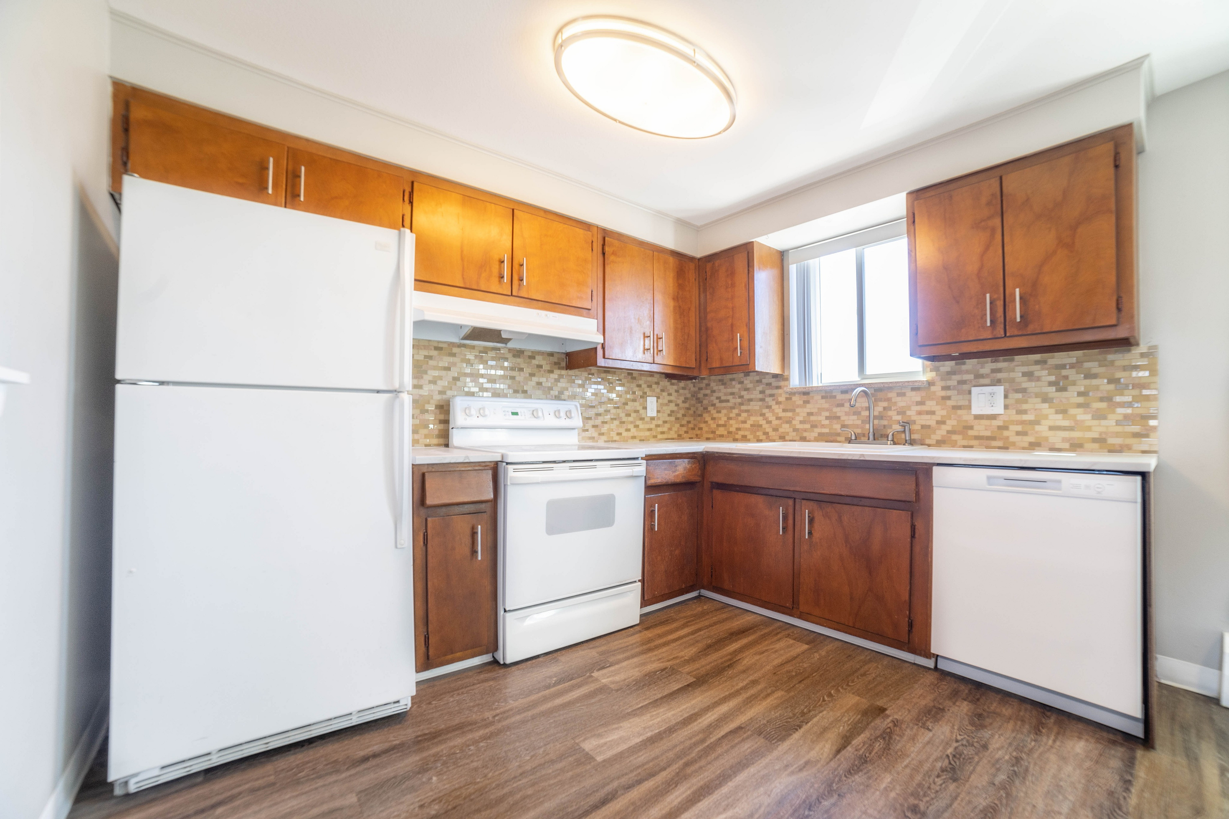 Charming kitchen with warm wooden cabinets, modern appliances, and elegant tile backsplash, offering a perfect blend of style and functionality.