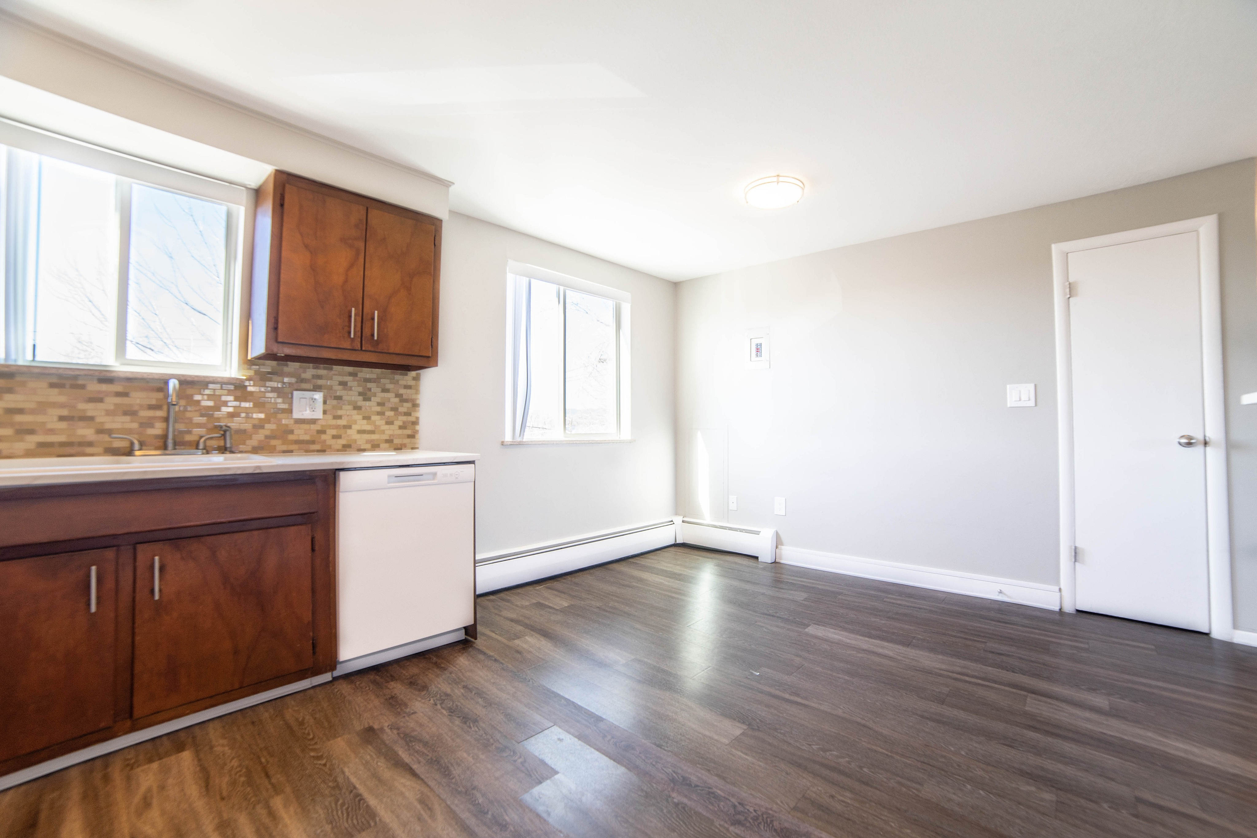 Inviting kitchen space featuring elegant wood cabinetry, sleek countertops, and ample sunlight through large windows.