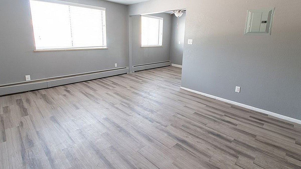 Modern apartment interior with sleek gray walls, expansive windows, and elegant hardwood flooring, perfect for a cozy and inviting atmosphere.