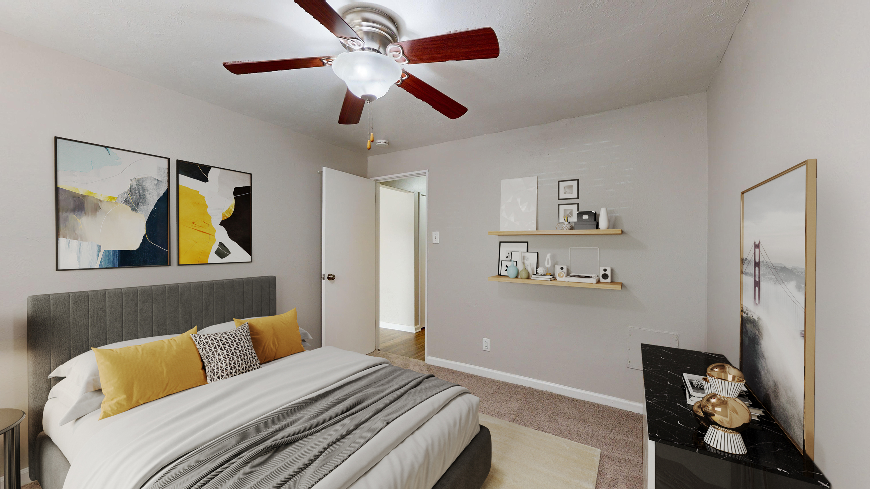 Inviting bedroom with contemporary decor, featuring a stylish queen bed with yellow accents, modern ceiling fan, and elegant artwork on the walls.