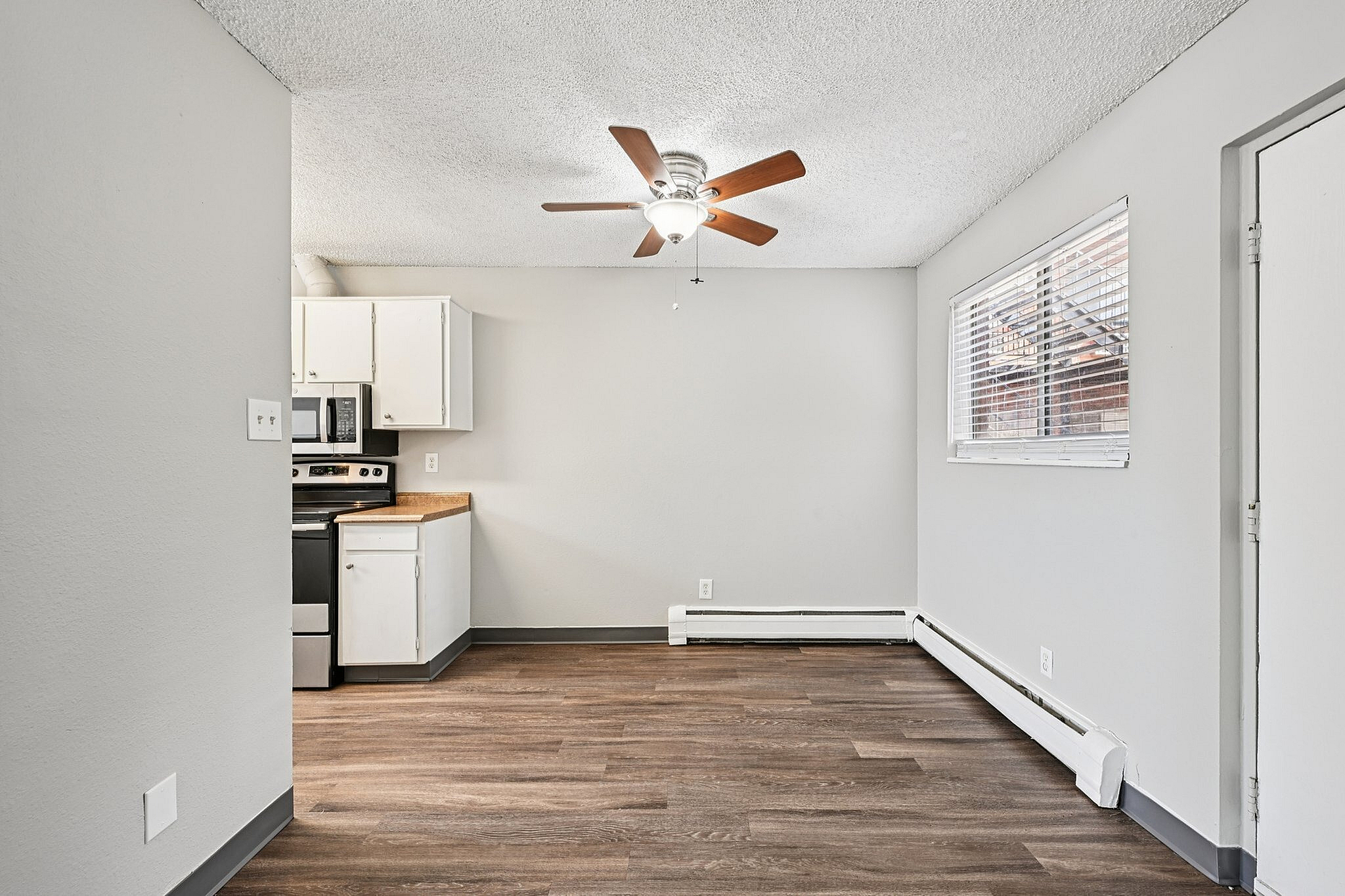 Charming open-plan kitchen and living area with modern appliances and warm wooden flooring.