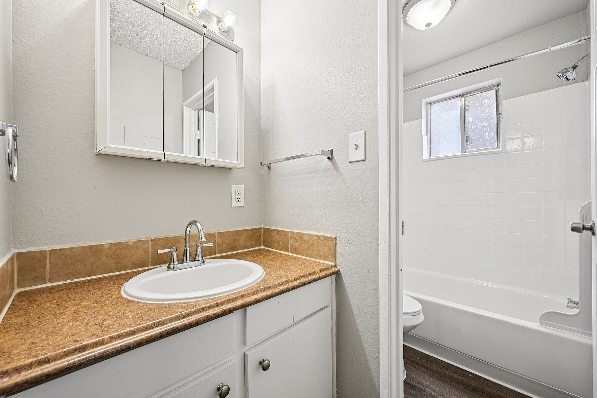 Bright and inviting bathroom featuring a modern sink, elegant mirror, and ample natural light enhancing the space.